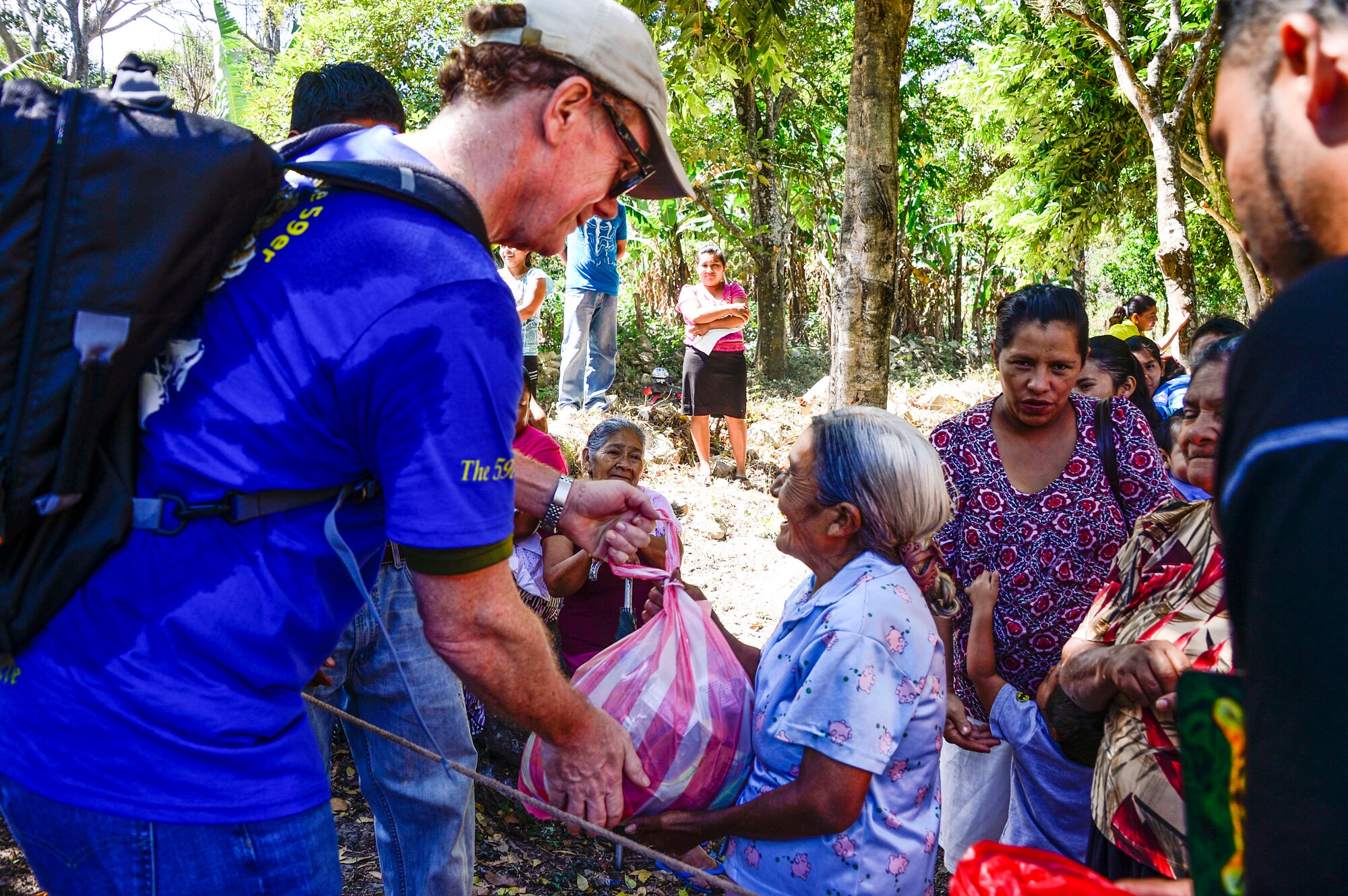 U.S. Ambassador to the Republic of Honduras, James Nealon, passes his bag of donated food and supplies to a villager in Laguna, Honduras, Feb. 28, 2015. As part of the 59th Chapel Hike, more than 172 members assigned to Joint Task Force-Bravo laced up their hiking boots and completed a seven-mile round trip hike to deliver over 4,500-pounds of donated try goods to villagers in need. (U.S. Air Force photo/Tech. Sgt. Heather Redman) 