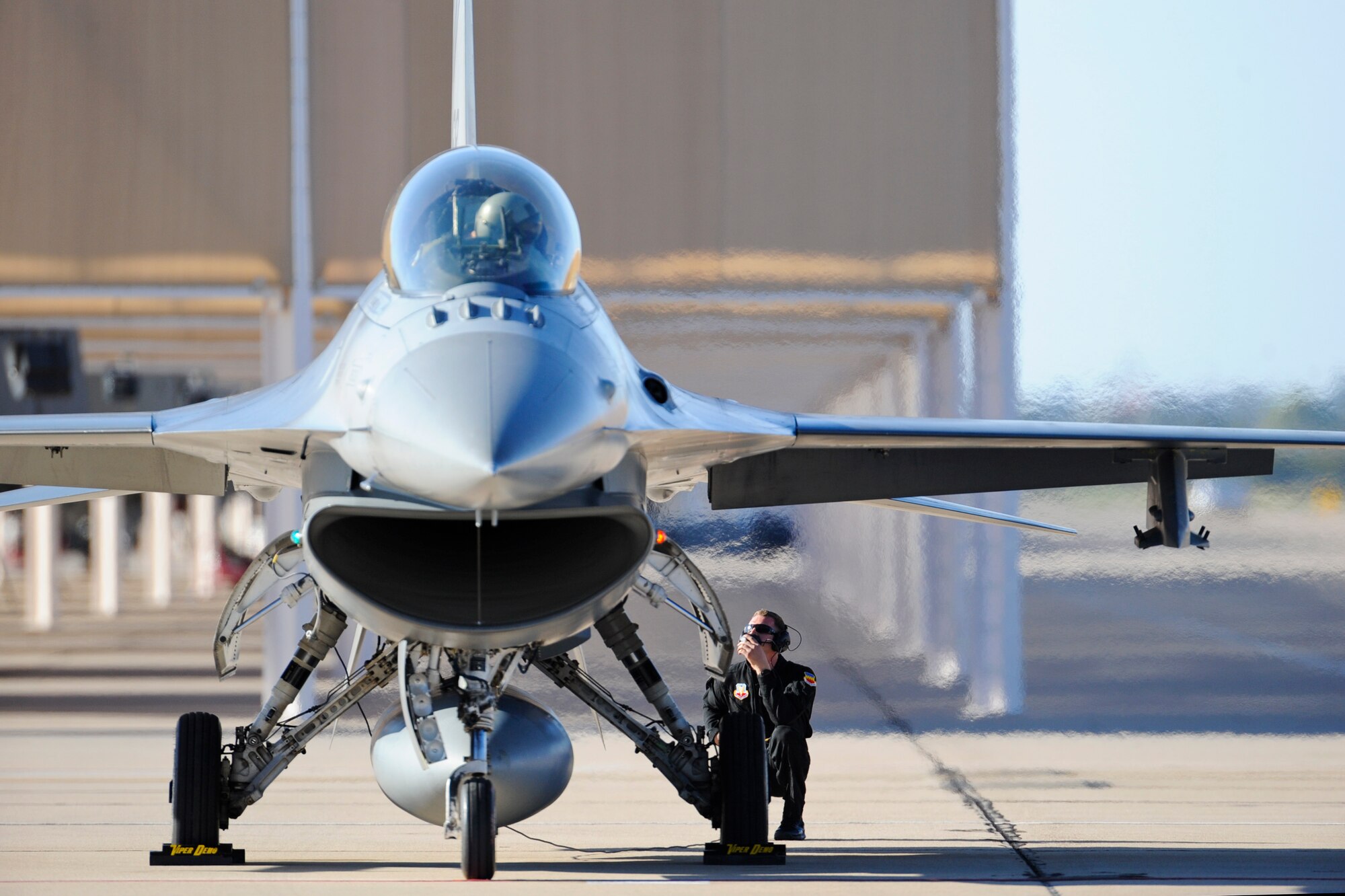 An F-16 Fighting Falcon pilot and crew chief communicate while preparing for a flight during the 2015 Heritage Flight Training and Certification Course at Davis-Monthan Air Force Base, Ariz., Feb. 27, 2015.  During the course, aircrews practiced ground and flight training to enable civilian pilots of historic military aircraft and U.S. Air Force pilots of current fighter aircraft to fly safely in formations together. (U.S. Air Force photo by Airman 1st Class Chris Massey/Released)