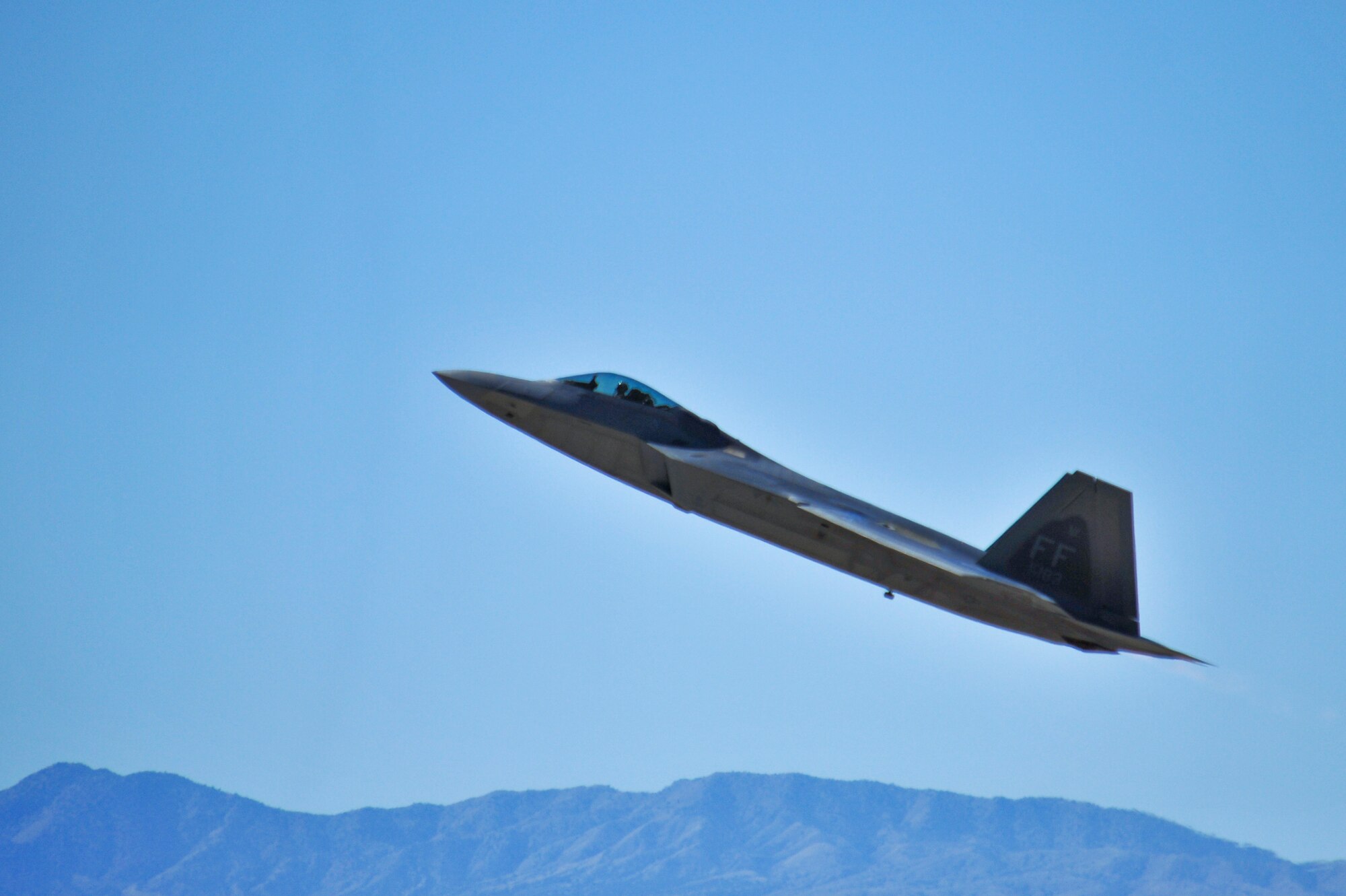 An F-22 Raptor performs and aerial maneuver during the 2015 Heritage Flight Training and Certification Course at Davis-Monthan Air Force Base, Ariz., Feb. 26, 2015. The annual aerial demonstration training event has been held at D-M since 2001, providing civilian and military pilots the opportunity to practice flying in formation for the upcoming air show season. (U.S. Air Force photo by Airman 1st Class Chris Massey/Released)