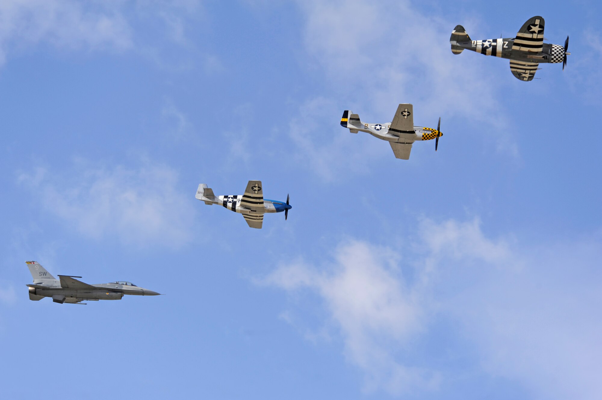 An F-16 Fighting Falcon, two P-51 Mustangs and a P-47 Thunderbolt fly in formation together during the 2015 Heritage Flight Training and Certification Course at Davis-Monthan Air Force Base, Ariz., Feb. 28, 2015. The aircraft that participated in this year’s course were the historic P-51 Mustang, P-40 Warhawk, P-38 Lightning, P-47 Thunderbolt, F-86 Sabre, along with the current F-22 Raptor and F-16 Fighting Falcon. (U.S. Air Force photo by Airman 1st Class Betty R. Chevalier)