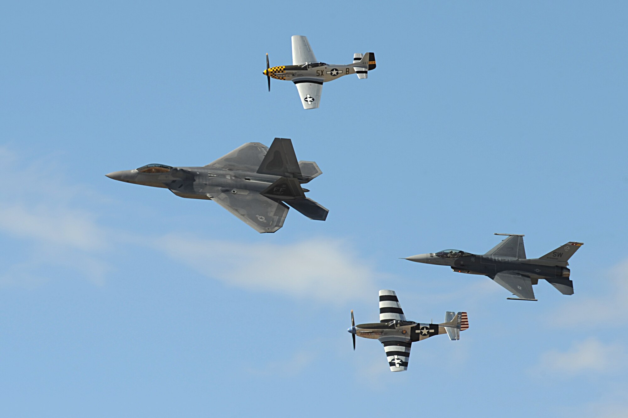 A U.S. Air Force F-22 Raptor, two P-51 Mustangs and an F-16 Fighting Falcon fly in formation during the 2015 Heritage Flight Training and Certification Course at Davis-Monthan Air Force Base Ariz., March 1, 2015. Established in 1997, the HFTCC featured aerial demonstrations from historical and modern fighter aircraft which will fly in formation together during air shows across the country. (U.S. Air Force photo by Airman 1st Class Chris Drzazgowski/Released)