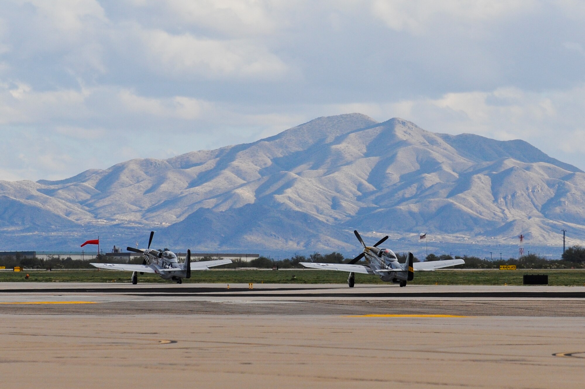 Two P-51 Mustangs taxi down the flightline during the 2015 Heritage Flight Training and Certification Course at Davis-Monthan Air Force Base, Ariz., Feb. 28, 2015. During the course, aircrews practiced ground and flight training to enable civilian pilots of historic military aircraft and U.S. Air Force pilots of current fighter aircraft to fly safely in formations together. (U.S. Air Force photo by Airman 1st Class Chris Drzazgowski/Released)