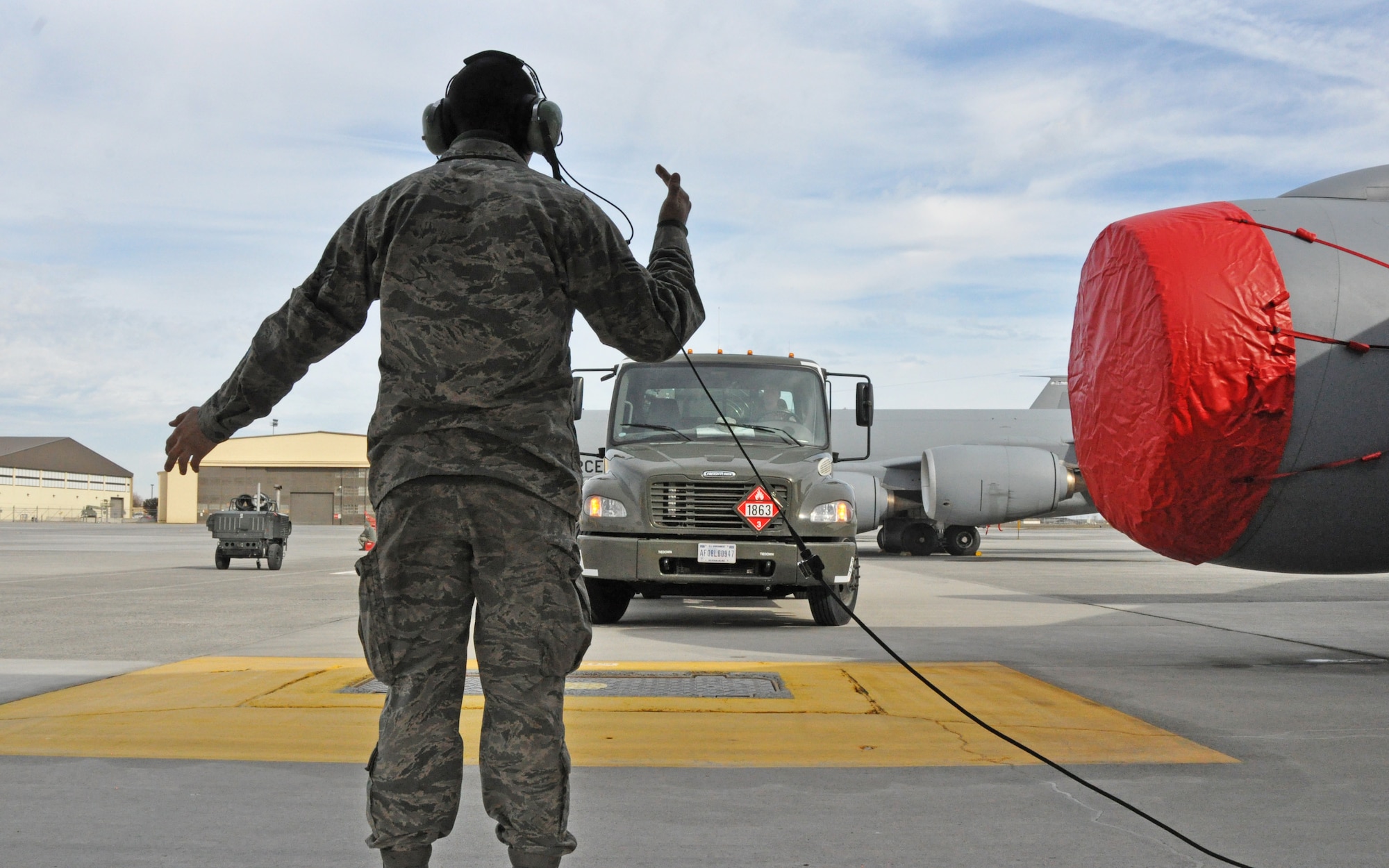 Senior Airman Roberto Tellez-Barrios, a 92nd Maintenance Squadron KC-135 Stratotanker crew chief, marshals an R-12 hydrant servicing vehicle to his aircraft in preparation for refueling operations Feb. 18, 2015, at Fairchild Air Force Base, Wash. Both 92nd MXS and 92nd Logistics Readiness Squadron fuels distribution element Airmen work together to fill the KC-135 with up to 30,000 gallons of jet fuel to be used to extend the reach of U.S. military aircraft from all branches of service as they perform training and operational missions in support of homeland defense, transport and other military operations. (U.S. Air Force photo/Capt. David Liapis)
