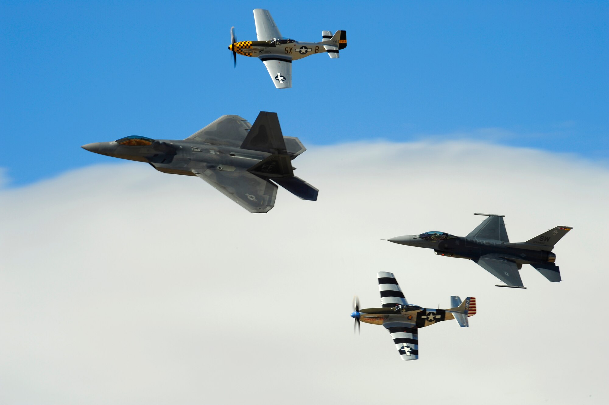 A F-22 Raptor, two P-51 Mustangs and a F-16 Fighting Falcon practice flying in formation during the 2015 Heritage Flight Training and Certification Course at Davis-Monthan Air Force Base, Ariz., March 1, 2015. During the course, aircrews practiced ground and flight training to enable civilian pilots of historic military aircraft and U.S. Air Force pilots of current fighter aircraft to fly safely in formations together. (U.S. Air Force photo by Tech. Sgt. Courtney Richardson/Released)