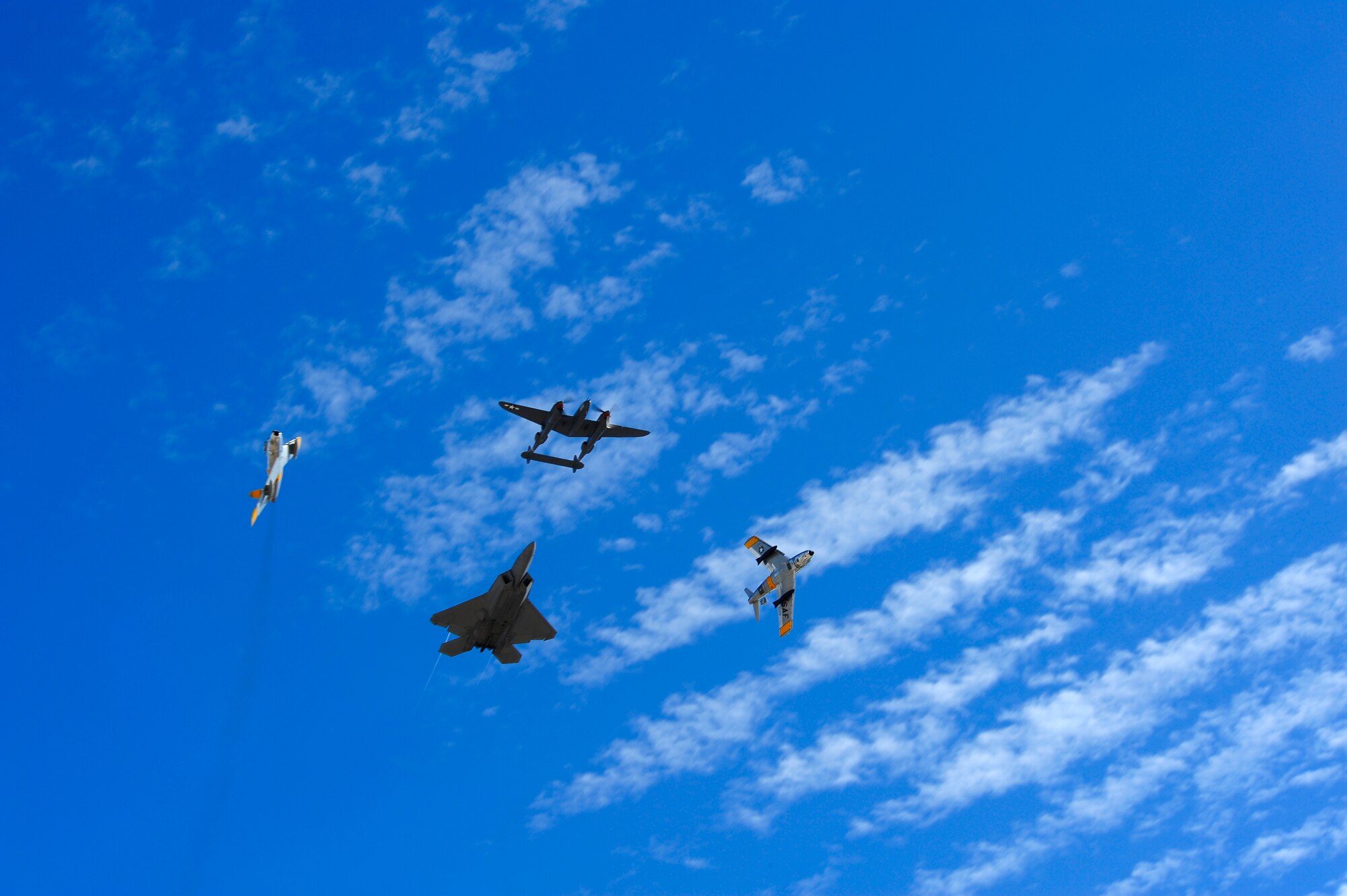A P-38 Lightning, two F-86 Sabres and a F-22 Raptor fly in formation together during the 2015 Heritage Flight Training and Certification Course at Davis-Monthan Air Force Base, Ariz., Feb. 28, 2015. Established in 1997, the HFTCC featured aerial demonstrations from historical and modern fighter aircraft which will fly in formation together during Air Shows across the country. (U.S. Air Force photo by Staff Sgt. Courtney Richardson/Released)