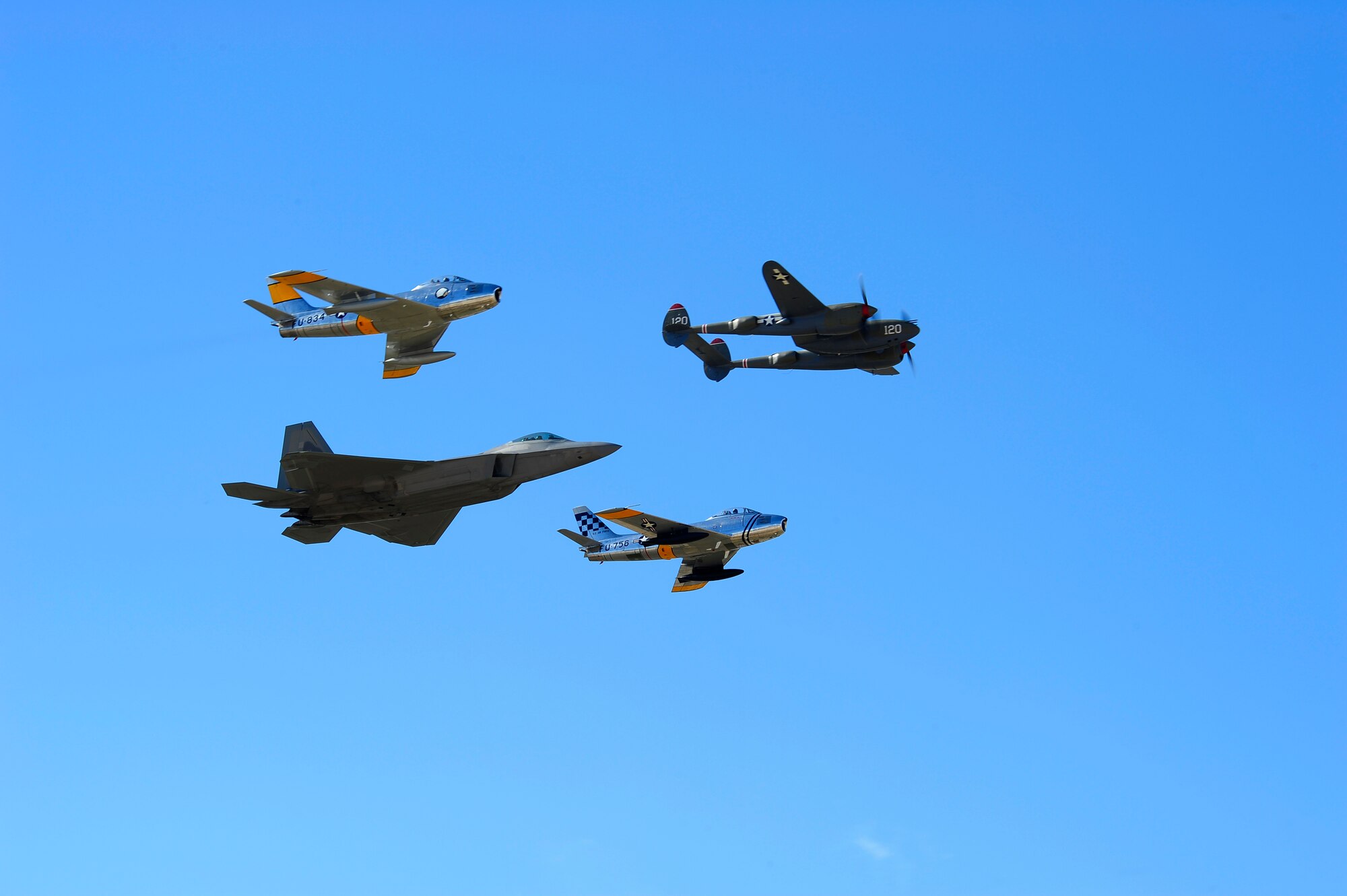 A P-38 Lightning, two F-86 Sabres and a F-22 Raptor fly in formation together during the 2015 Heritage Flight Training and Certification Course at Davis-Monthan Air Force Base, Ariz., Feb. 28, 2015. During the course, aircrews practiced ground and flight training to enable civilian pilots of historic military aircraft and U.S. Air Force pilots of current fighter aircraft to fly safely in formations together. (U.S. Air Force photo by Staff Sgt. Courtney Richardson/Released)