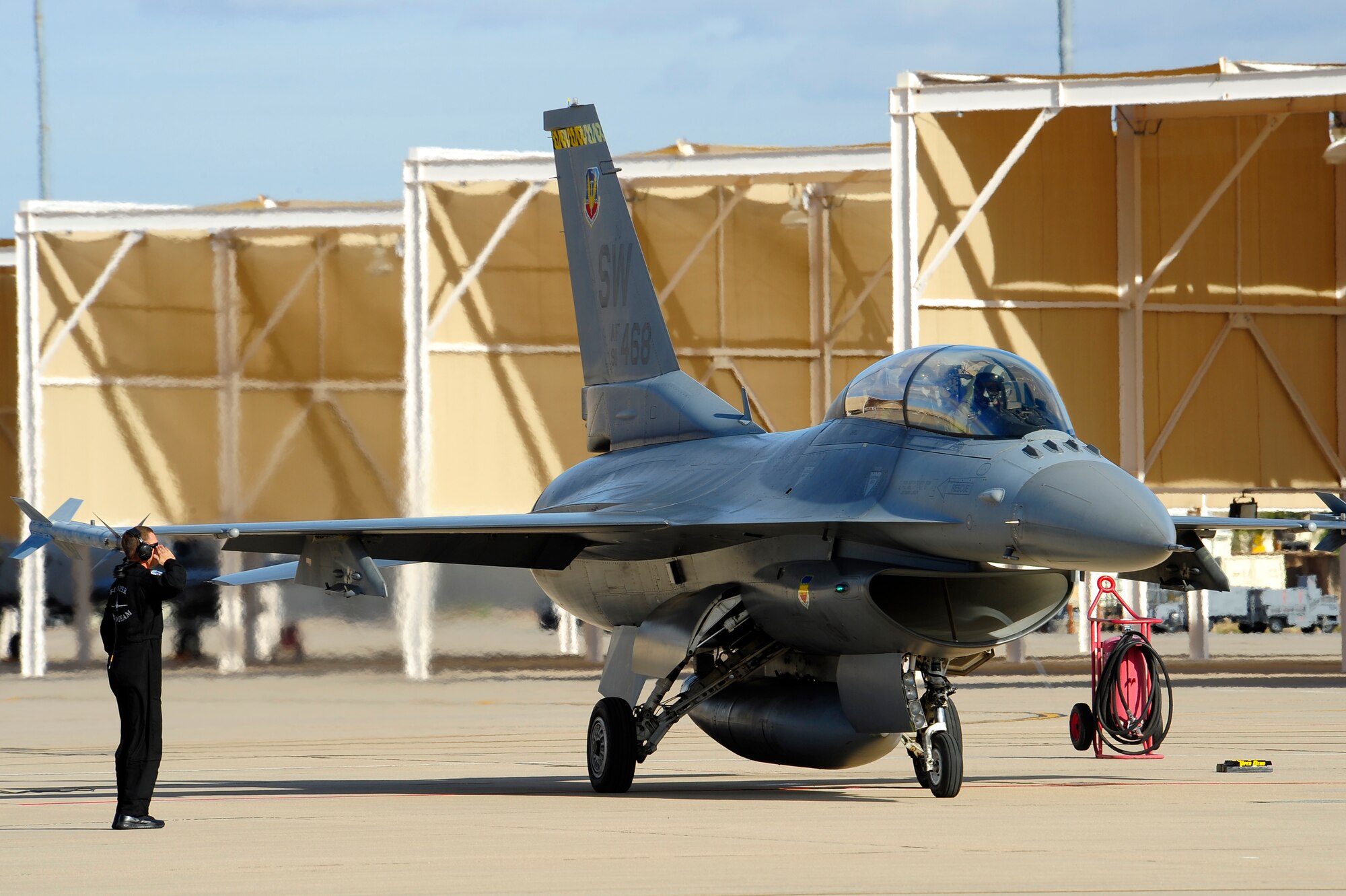 U.S. Air Force Capt. Craig Baker, F-16 Viper Demonstration Team commander and pilot, salutes his crew chief as he taxis to the runway during the 2015 Heritage Flight Training and Certification Course at Davis-Monthan Air Force Base, Ariz., Feb. 28, 2015. During the course, aircrews practiced ground and flight training to enable civilian pilots of historic military aircraft and U.S. Air Force pilots of current fighter aircraft to fly safely in formations together. (U.S. Air Force photo by Staff Sgt. Courtney Richardson/Released)