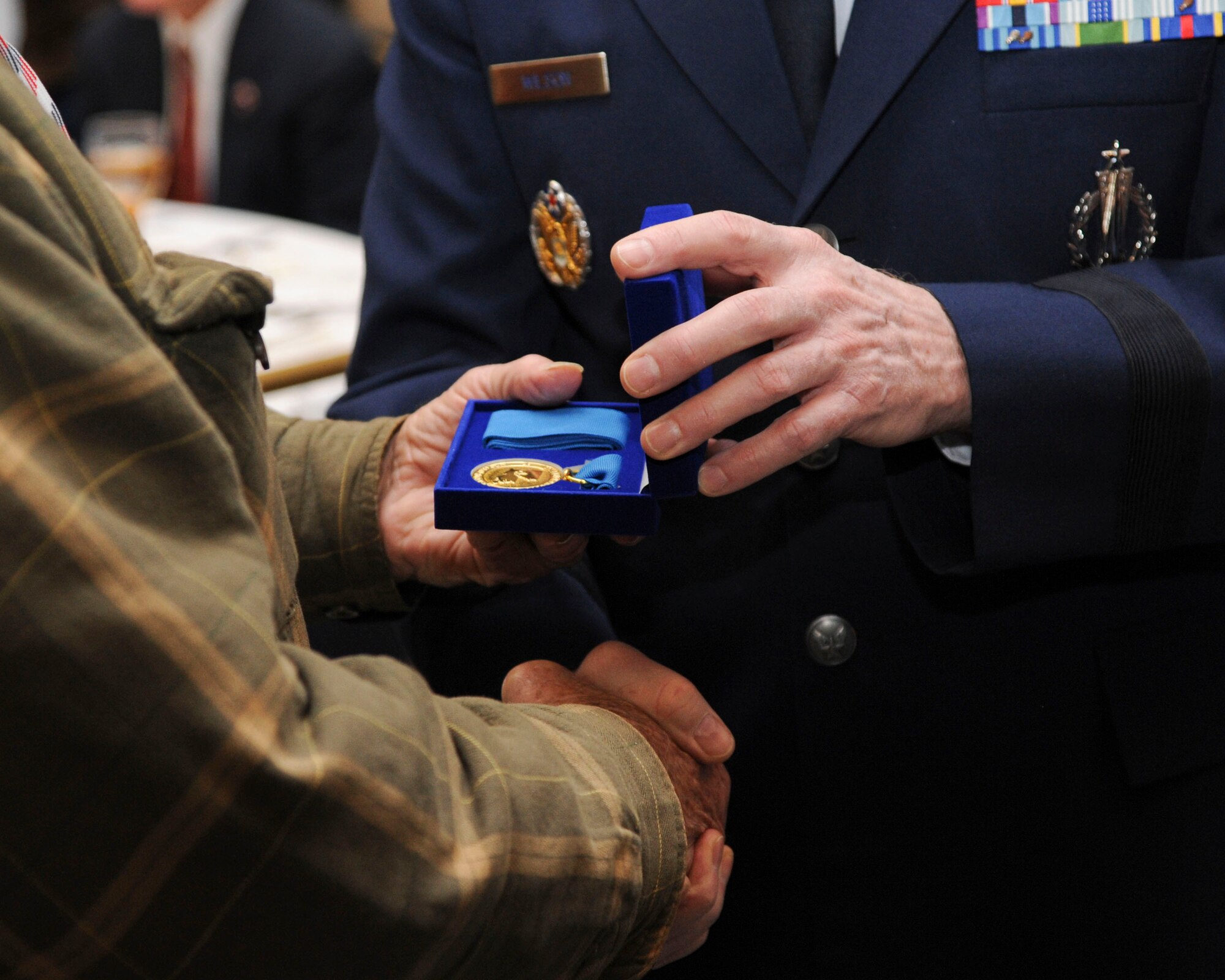 Lt. Gen. Stephen Wilson, Air Force Global Strike Command commander, presents the Louisiana Veterans Honor Medal to a World War II veteran during the WWII luncheon on Barksdale Air Force Base, La., Feb. 27, 2015. The medal is given to recognize all members who have served during the war. (U.S. Air Force photo/ Senior Airman Jannelle Dickey)