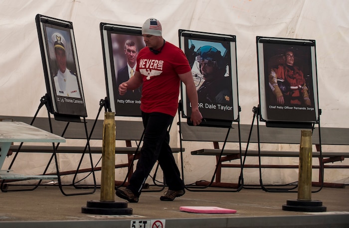 Lt. Shannon Scaff walks past posters of Coast Guardsmen killed in a helicopter crash. Scaff swam for 24 hours Feb. 27, 2015 at the Martin Luther King Jr. Pool in Charleston, S.C. He swam to honor the fallen service members and raise money for a non-profit organization. Scaff swam nearly 28 miles in honor of his friend, Coast Guard Lt. Commander Dale Taylor, who lost his life in a helicopter crash with three other Coast Guardsmen Feb. 28, 2012. Scaff is a U.S. Coast Guard’s Maritime Law Enforcement Academy Public Affairs officer and a former helicopter rescue swimmer stationed in Charleston. (U.S. Air Force photo/Senior Airman Jared Trimarchi) 