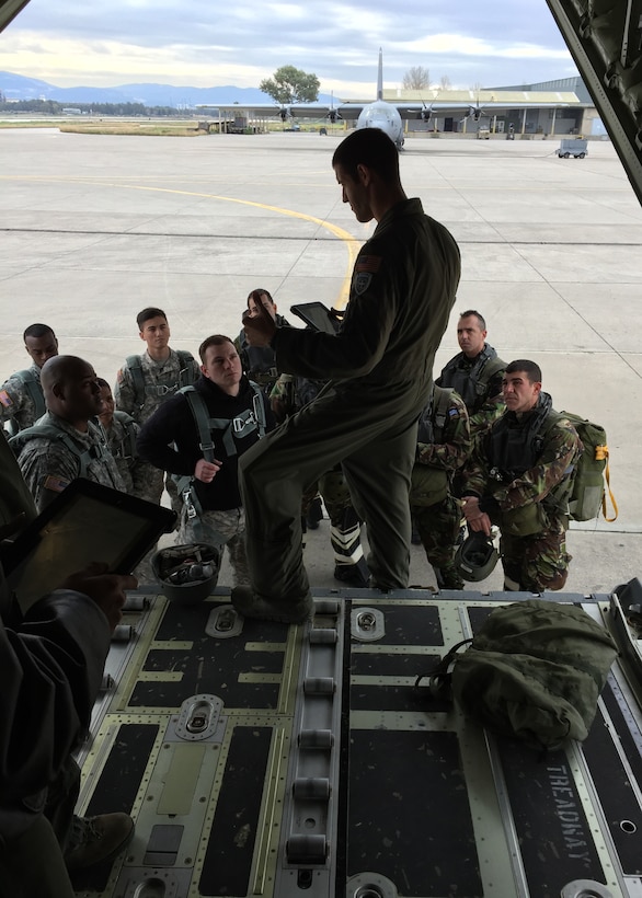 A U.S. Air Force Airman assigned to the 317th Airlift Group administers a brief to U.S. Soldiers and members of the Hellenic Air Force Feb. 9, 2015, at Elefsis Air Base, Greece. The 317th AG joined forces with Airmen and Soldiers from U.S. European Command to work with the Hellenic Air Force during the Stolen Cerberus II exercise, where the mission was to develop joint cohesion and determine the interoperability amongst all units. (Courtesy photo)