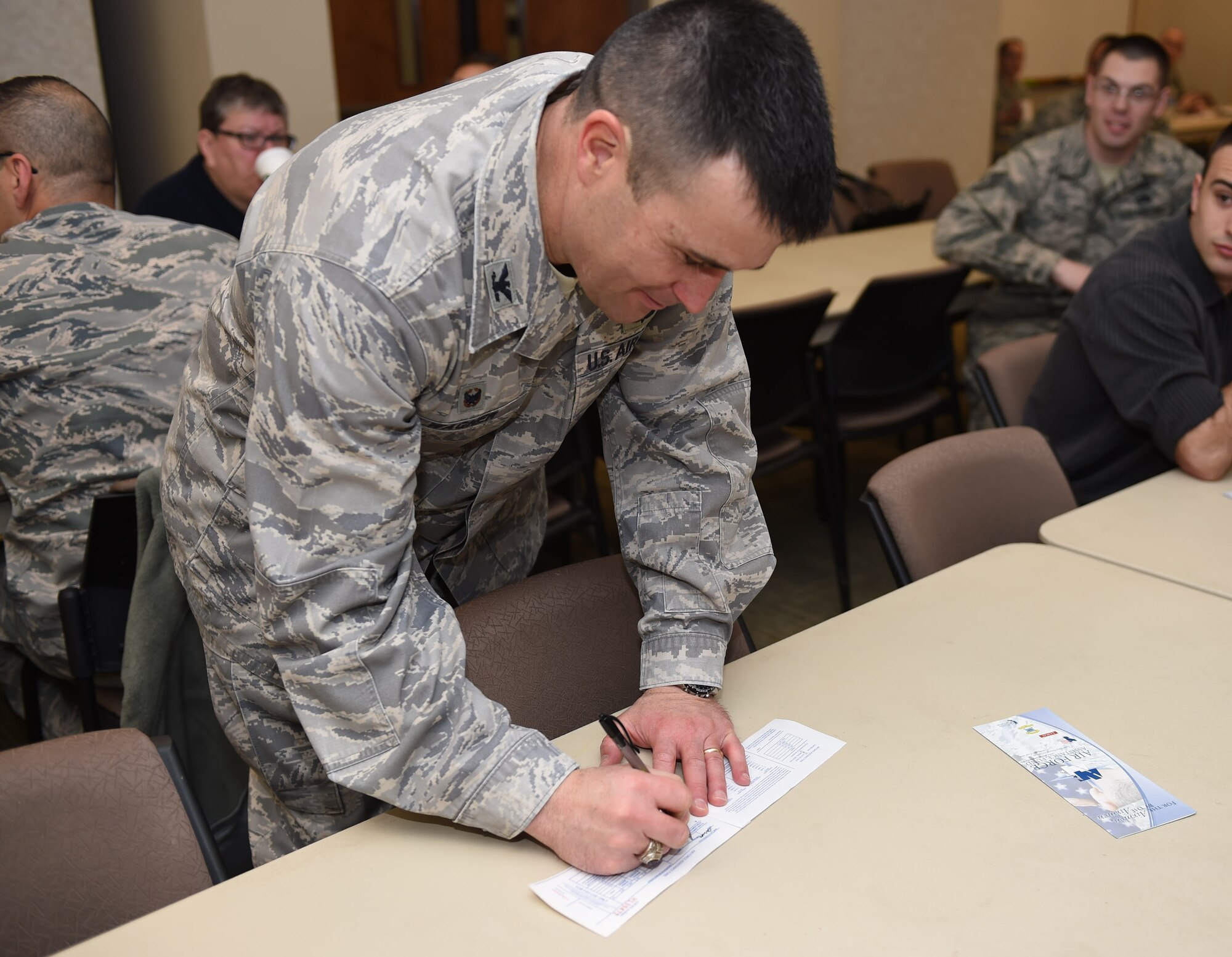 Col. John Wagner, 460th Space Wing commander, fills out a pledge card to donate to the Air Force Assistance Fund March 3, 2015, at the chapel on Buckley Air Force Base, Colo. The AFAF is designed to support Airmen and their families who are going through hardships such as family emergencies or financial troubles. (U.S. Air Force photo by Airman 1st Class Samantha Saulsbury/Released)