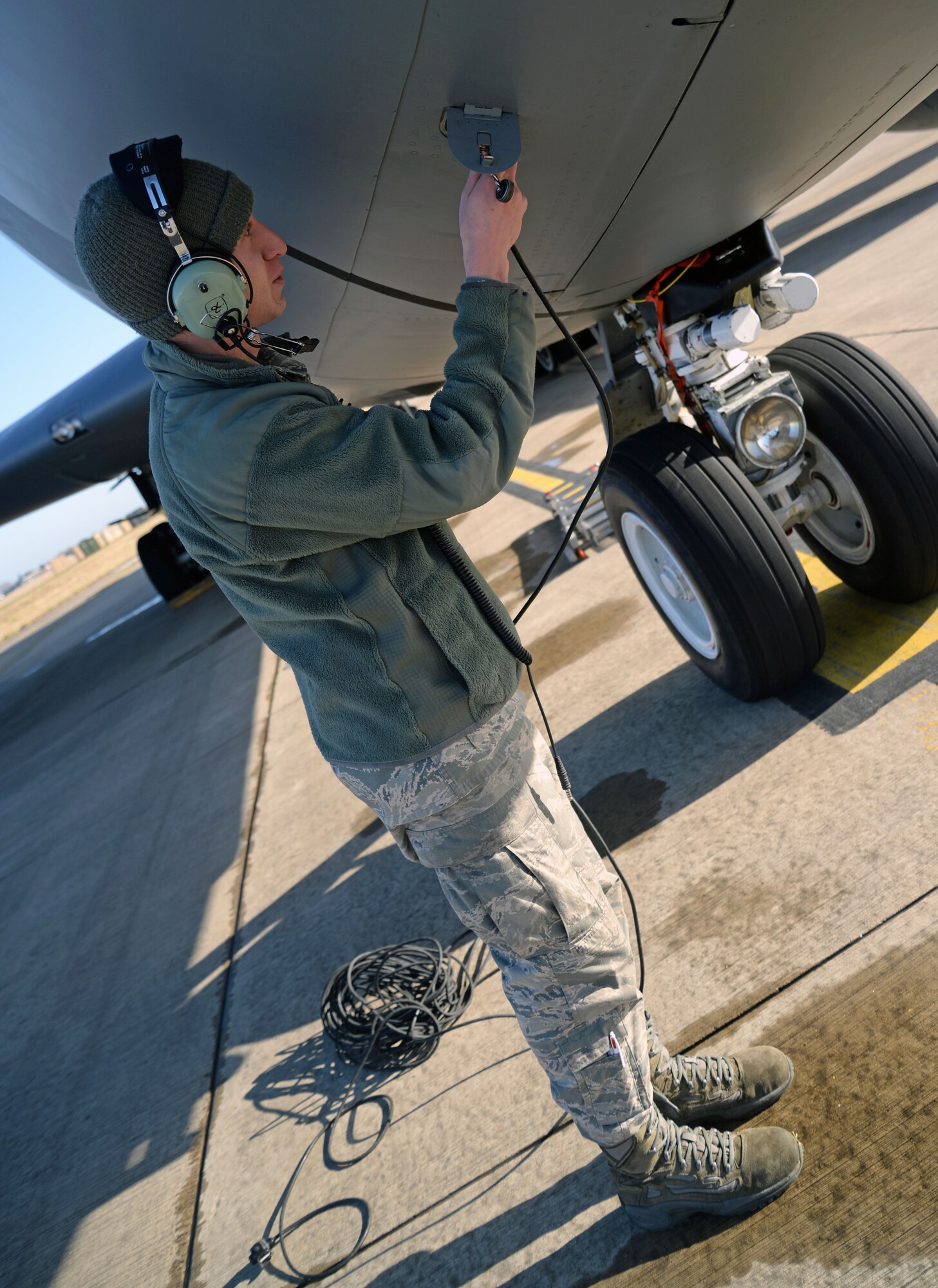U.S. Air Force Senior Airman Joshua Simring, 100th Aircraft Maintenance Squadron instruments and flight control systems journeyman from Orlando, Fla., plugs a communications cord in to a KC-135 Stratotanker Feb. 27, 2015, on RAF Mildenhall, England. Simring earned the Square D Spotlight for exhibiting the Air Force’s core value: Excellence in All We Do. (U.S. Air Force photo by Senior Airman Christine Griffiths/Released)