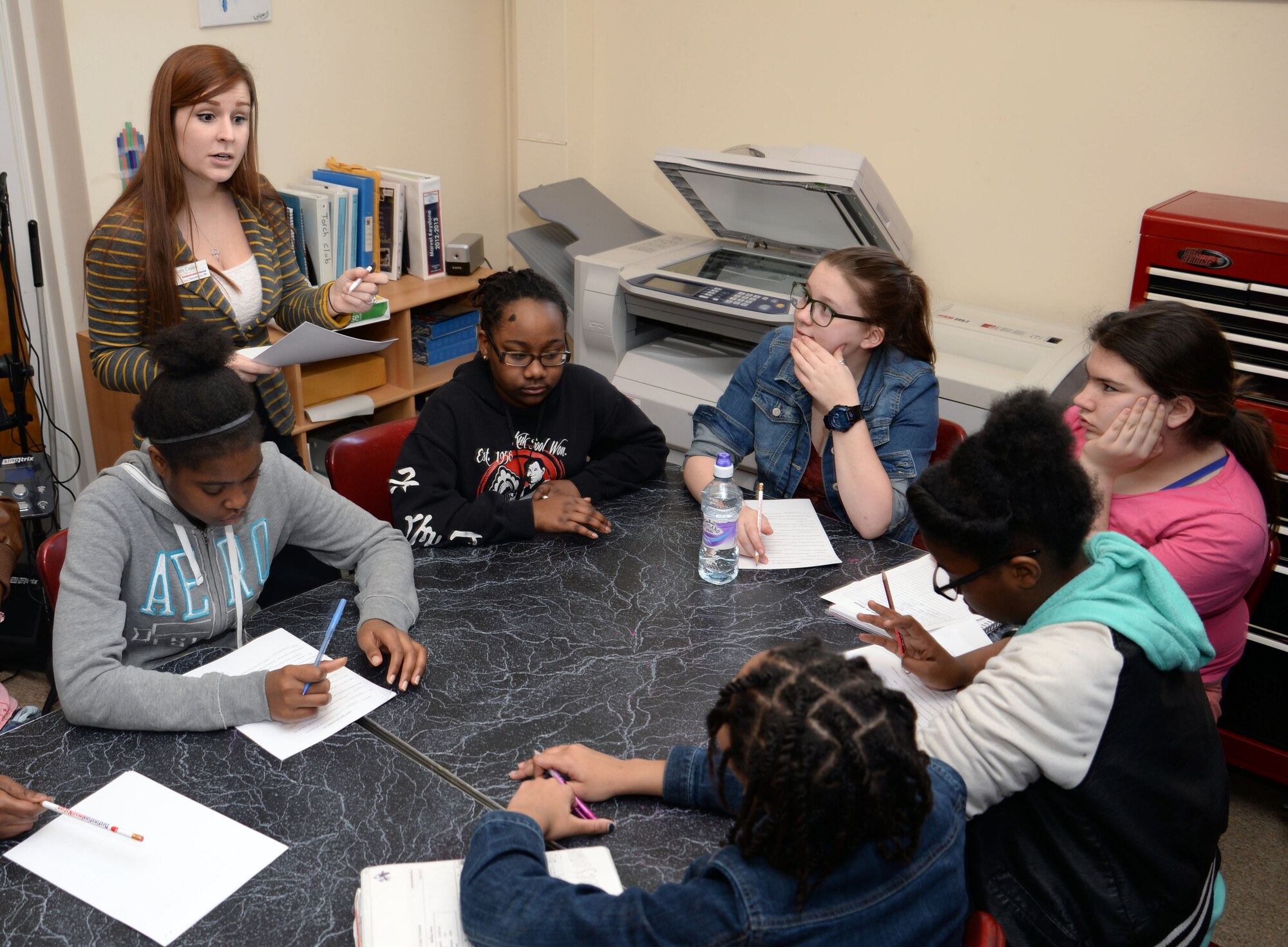 Kristen Capps, a bank teller from on-base, teaches Mildenhall Torch Club teens the importance of finances through various activities Feb. 27, 2015, at the Youth Center on RAF Mildenhall, England. The Military Saves campaign aims to educate Airmen and their families on the importance of saving money, and encourages them to take control of their finances. (U.S. Air Force photo by Senior Airman Christine Griffiths/Released)