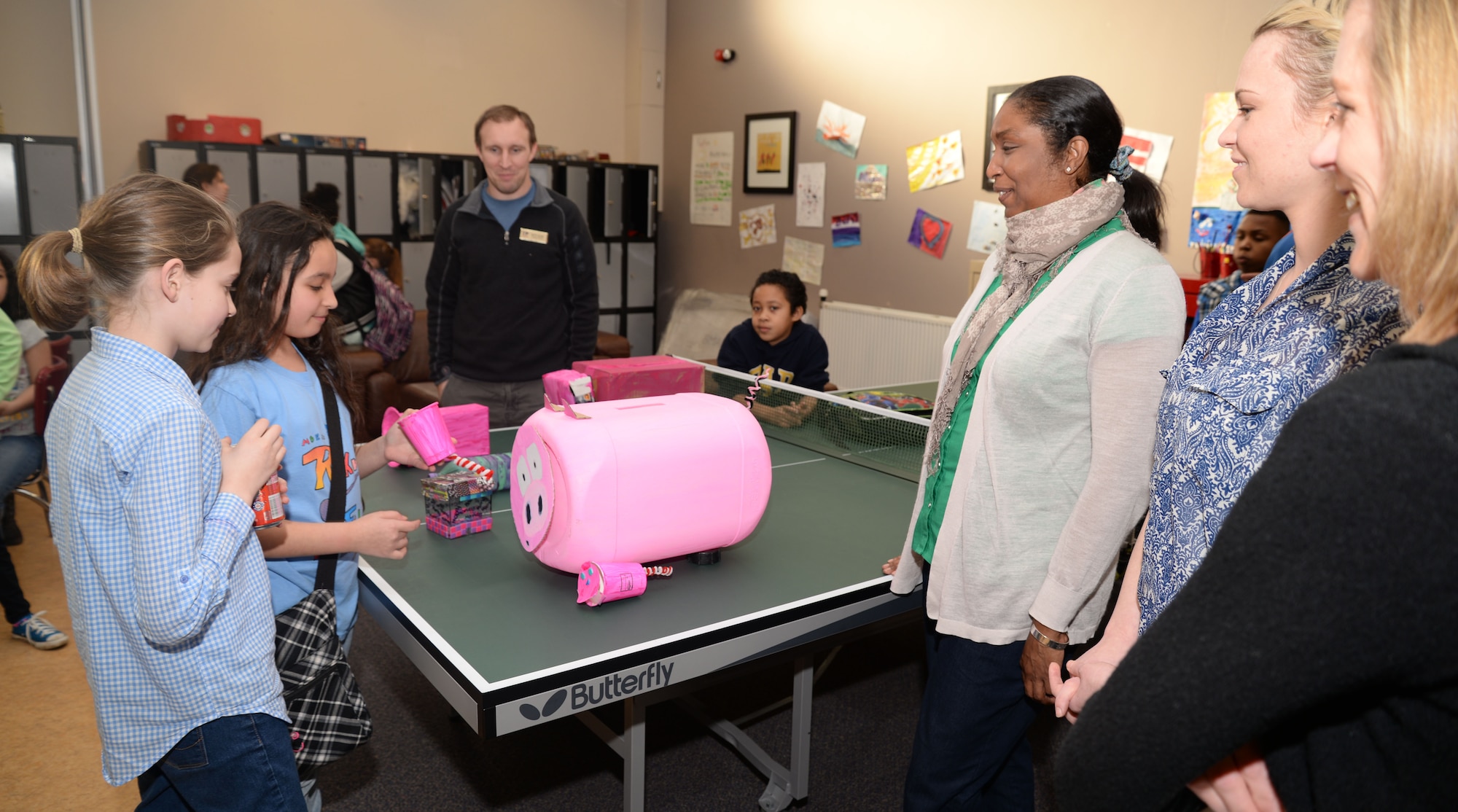 Youth Center students, left, present their entry for the “Military Saves Week: build a savings bank” contest to the Airmen and Family Readiness Center judges, right, Feb. 27, 2015, at the Youth Center on RAF Mildenhall, England. The Military Saves campaign aims to educate Airmen and their families on the importance of saving money, and encourages them to take control of their finances. (U.S. Air Force photo by Senior Airman Christine Griffiths/Released) 