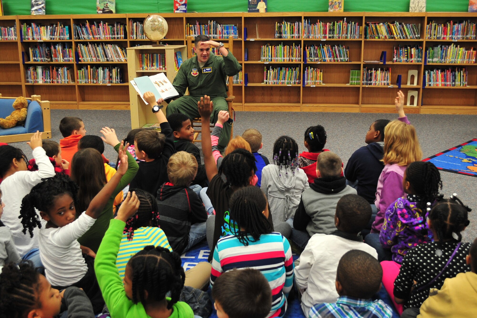 U.S. Air Force Maj. Mark Skalko, Chief of Ninth Air Force commander's action group, reads a book to a group of students at Shaw Heights Elementary School, Shaw Air Force Base, S.C., March 2, 2015. Skalko visited the school on Read Across America Day to encourage children to read and to raise awareness on the importance of a good education. (U.S. Air Force photo by Tech. Sgt. Ave I. Young/Released)