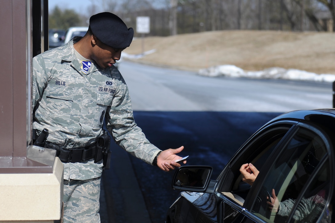 Airman 1st Class Gary Bills, an 11th Security Forces Squadron elite gate guard, checks Common Access Cards at the Virginia Gate on Joint Base Andrews, March 2, 2015. 11th SFS checks all IDs at JBA gates to ensure security on the installation. (U.S. Air Force photo/ Airman 1st Class J.D. Maidens)