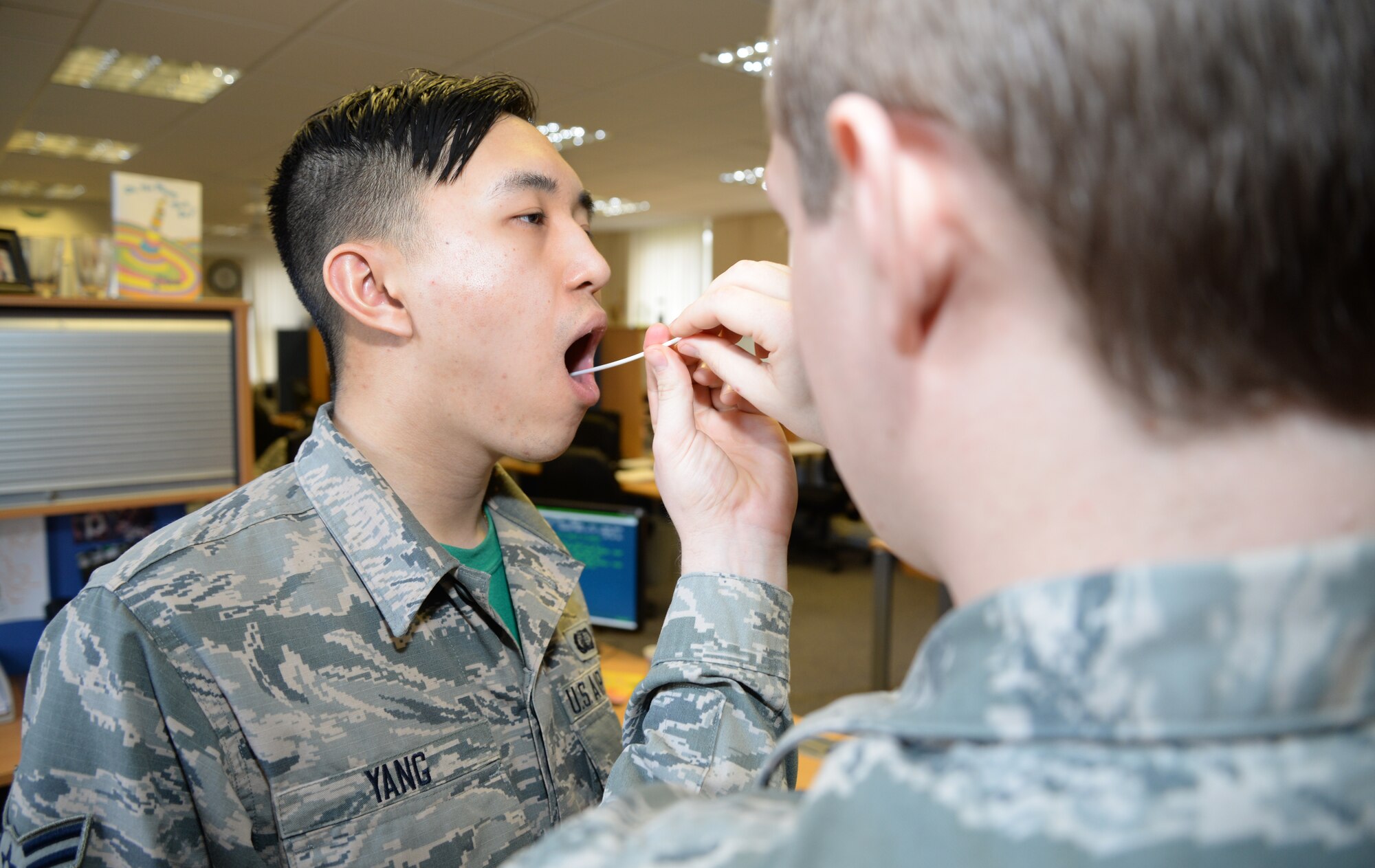 U.S. Air Force Airman 1st Class Leon Yang, left, 100th Comptroller Squadron budget analyst from Merced, Calif., submits DNA to join a bone marrow registry Feb. 27, 2015, on RAF Mildenhall, England. From this point, participants who donated DNA in the bone marrow drive could be called at any moment to save someone’s life. Approximately 500 people from 100th Air Refueling Wing registered to be a donor. (U.S. Air Force photo by Airman 1st Class Jonathan Light/Released) 