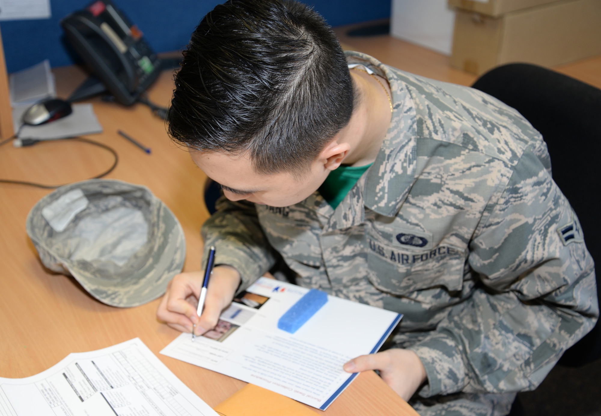 U.S. Air Force Airman 1st Class Leon Yang, 100th Comptroller Squadron budget analyst from Merced, Calif., fills out forms before getting his cheek swabbed for the bone marrow registry Feb. 27, 2015, on RAF Mildenhall, England. The drive was held from Feb. 23 to 27, 2015. Any U.S. citizen from the ages of 18 to 60 was allowed to register in the bone marrow drive. (U.S. Air Force photo by Airman 1st Class Jonathan Light/Released) 