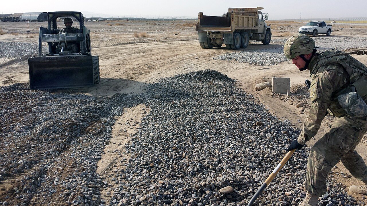 Air Force 1st Lt. Tim Lord lays gravel across an access road Feb. 13, 2015, at Kandahar Airfield, Afghanistan. Part of a two-member team, Lord and his enlisted counterpart, Air Force Staff Sgt. Gabriel Lara-Ortega, execute the functions of an average Air Force civil engineer squadron, usually composed of more than 100 airmen. Courtesy photo