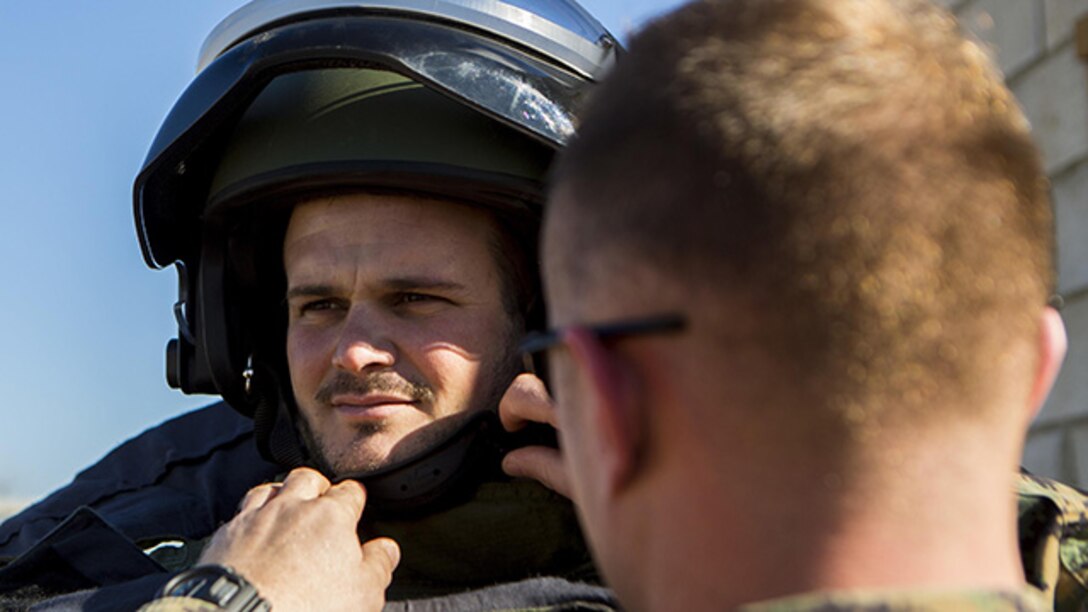 A U.S. Marine explosive ordnance disposal technician, right, with Special-Purpose Marine Air-Ground Task Force Crisis Response-Africa secures a bomb suit to Cabo Primero Antonio Diosdade, , a noncommissioned officer with Unidad Militar de Emergencias, an emergency response unit, during a joint training event at Morón Air Base, Spain, Feb. 18, 2015. The Marines demonstrated the different capabilities of their equipment for Spanish forces, who then provided a guided tour of the UME disaster training site to set the stage for future training opportunities. (U.S. Marine Corps photograph by Lance Cpl. Christopher Mendoza/Released)