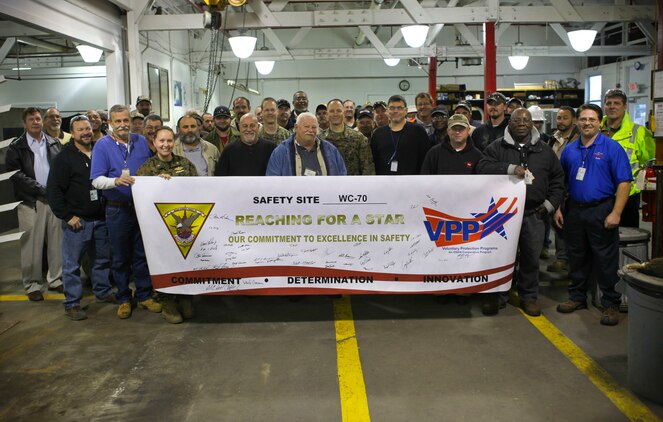 Facility workers gather to hold a banner for the introduction of the Voluntary Protection Program (VPP) Marine Corps Air Station Cherry Point, N.C., Jan. 14, 2015. VPP, facilitates change in safety culture. The goal is to create a proactive work environment to reduce mishaps and preserve limited resources, both personnel and property.
(U.S. Marine Corps photo by Lance Cpl Colin Broadstone/ Released)