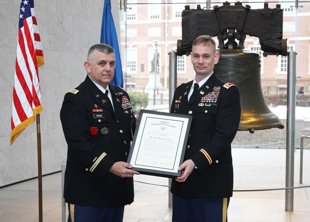 Col. Marc Ferraro (left), Acting Deputy Adjutant General of the Pennsylvania National Guard, pinned the rank of Lieutenant Colonel on Andrew Yoder (right) during a March 4, 2015 ceremony at the Liberty Bell. Yoder serves as the deputy commander of the U.S. Army Corps of Engineers Philadelphia District.
