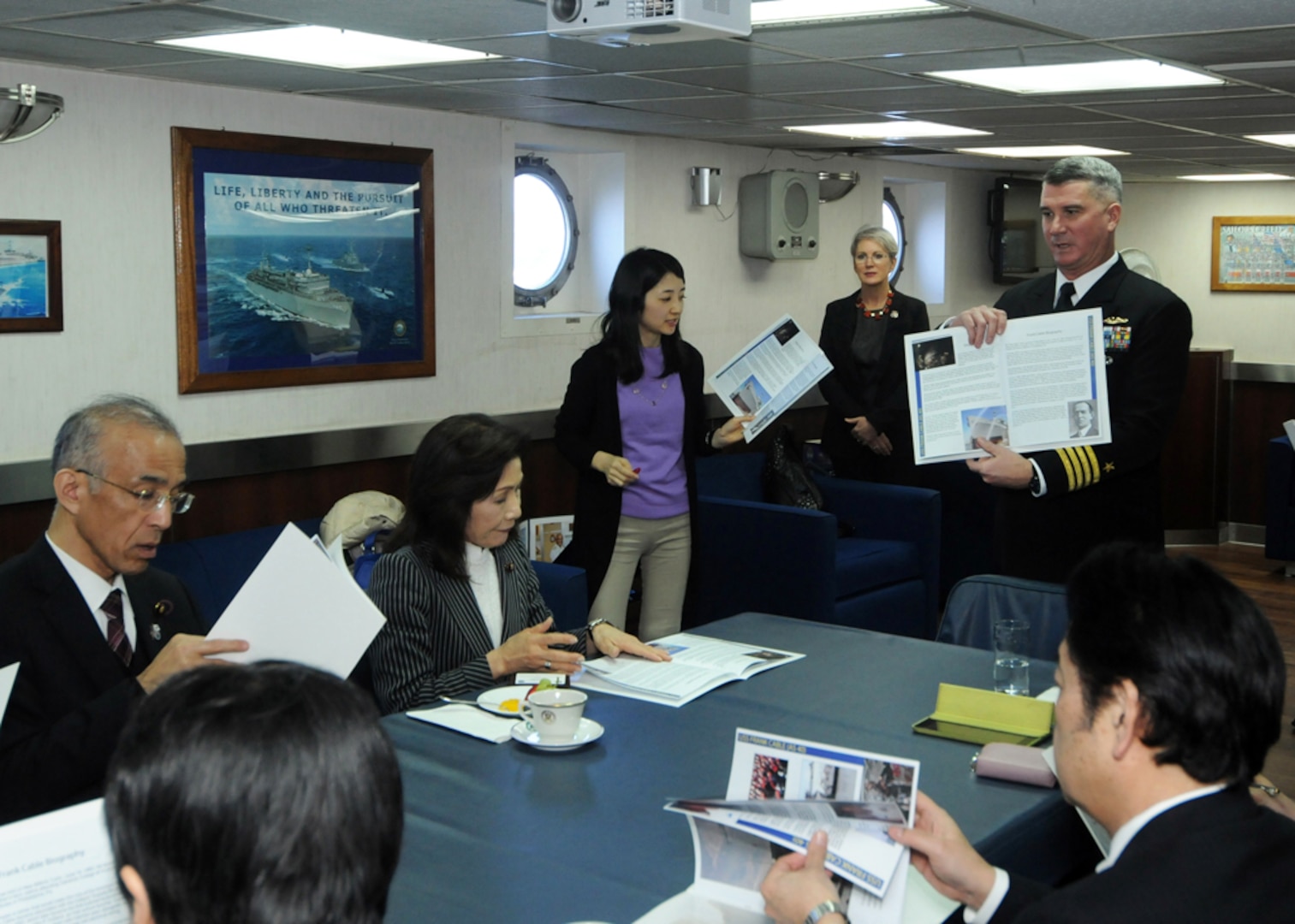 SASEBO, Japan (Mar. 2, 2015) - Capt. Mark Benjamin, right, commanding officer of the submarine tender USS Frank Cable (AS 40), explains his ship's history, capabilities, and functions to members of the Japanese House of Councilors (JHC). The members of the JHC came aboard to acquire knowledge about the role and function of the ships and facilities of Sasebo to aid in discussing issues related to the Japan-US alliance. Frank Cable, deployed to the island of Guam, conducts maintenance and support of submarines and surface vessels deployed to the U.S. 7th Fleet area of responsibility. 