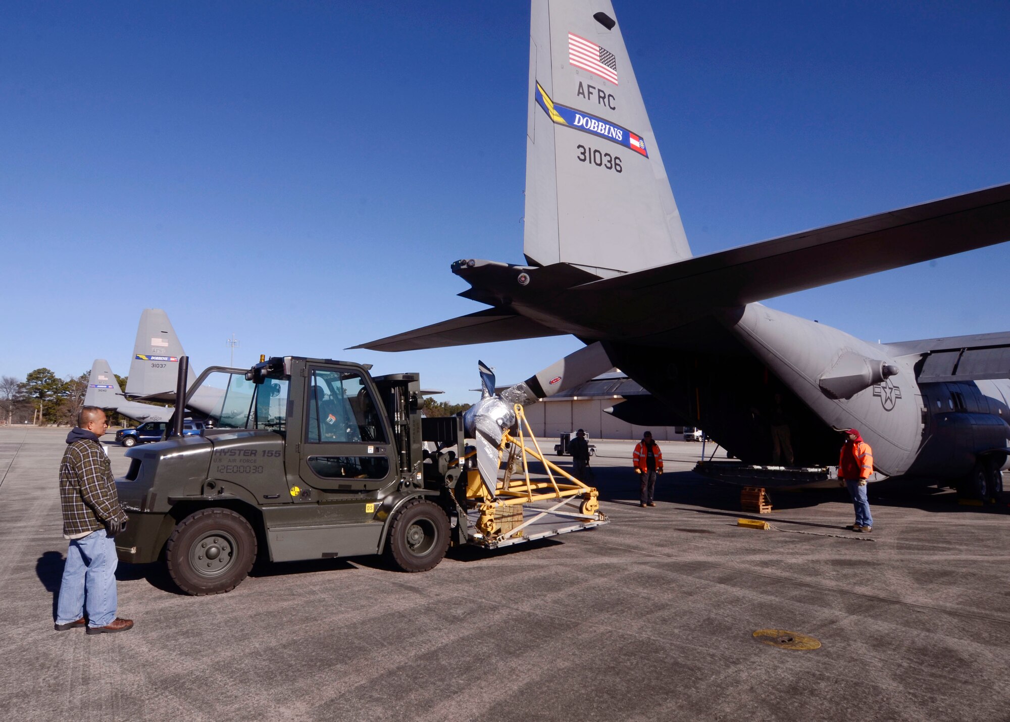 Members of the 94th Logistics Readiness Squadron, Dobbins Air Reserve Base, Ga. prepare and load cargo required by deployed personnel Jan. 6, 2015. Personnel appointed as inspector observe all aspects of the loading process ensuring all proper procedures are followed. (U.S. Air Force photo/Don Peek)