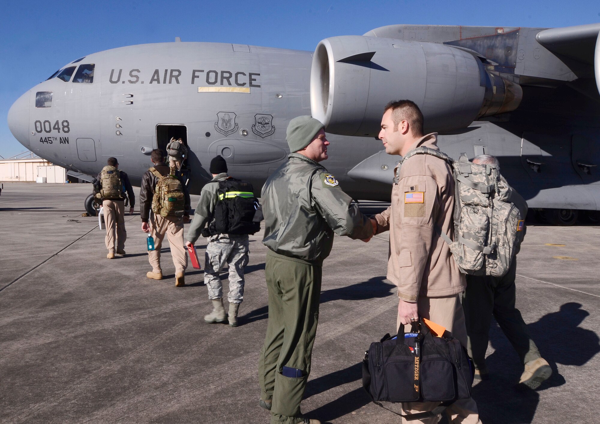 Col. James Devere, 94th Operations Group, commander wishes the deployment teams from Dobbins Air Reserve Base, Ga. well as they board the C-17 that will take them to the Central Command Area of Responsibility, Jan. 8, 2015. During deployment preparations, inspection teams observed various procedures, noting any process improvements. (U.S. Air Force photo/Don Peek)