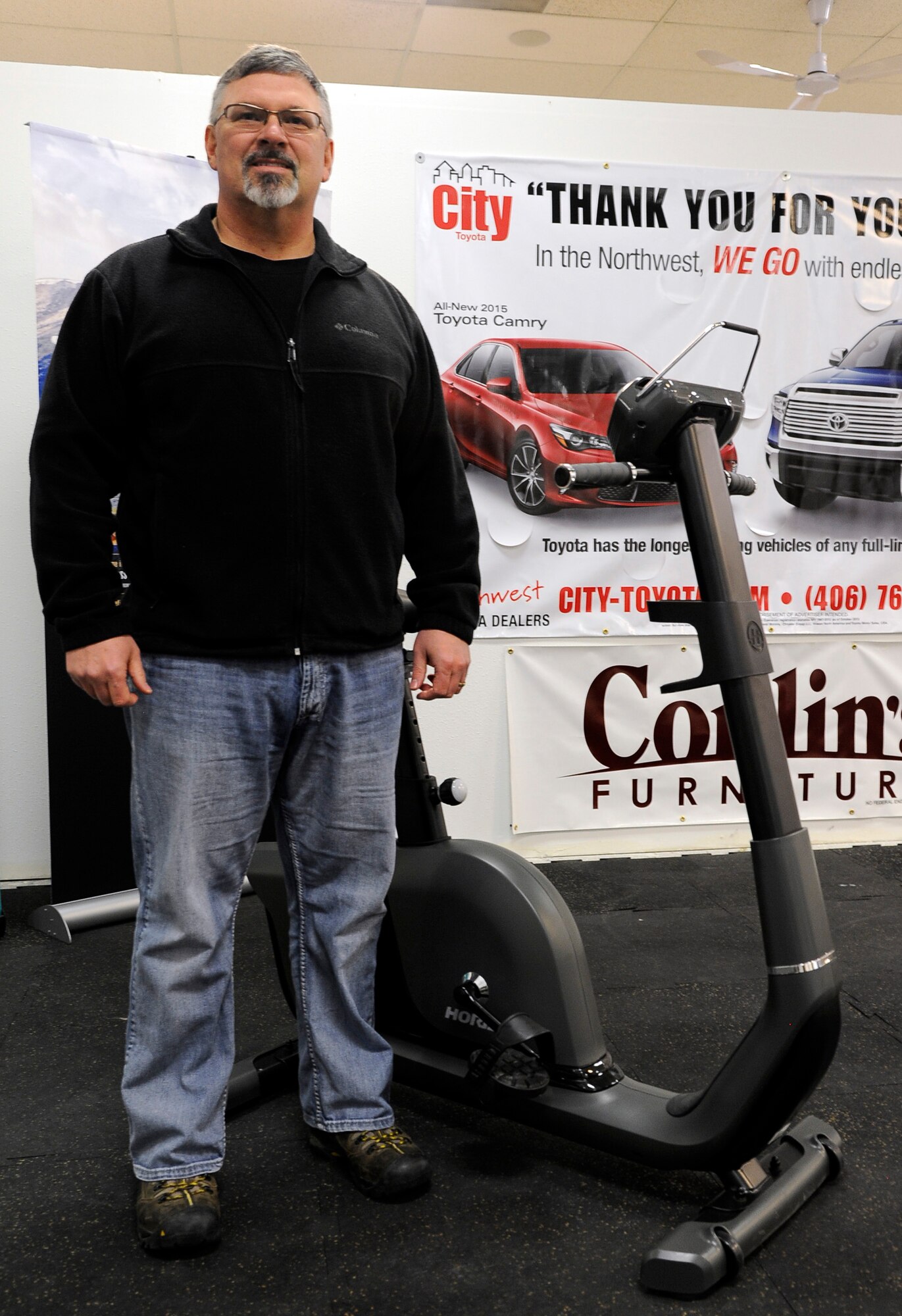 Paul Haas, 341st Security Support Squadron combat arms instructor, stands by the exercise bicycle he received for winning the Largest Loser Competition at Malmstrom Air Force Base, Mont. Haas joined the competition to get motivated to lose weight and lost 24 pound in the two month-long competition. (U.S. Air Force photo/Staff Sgt. Delia Marchick)
