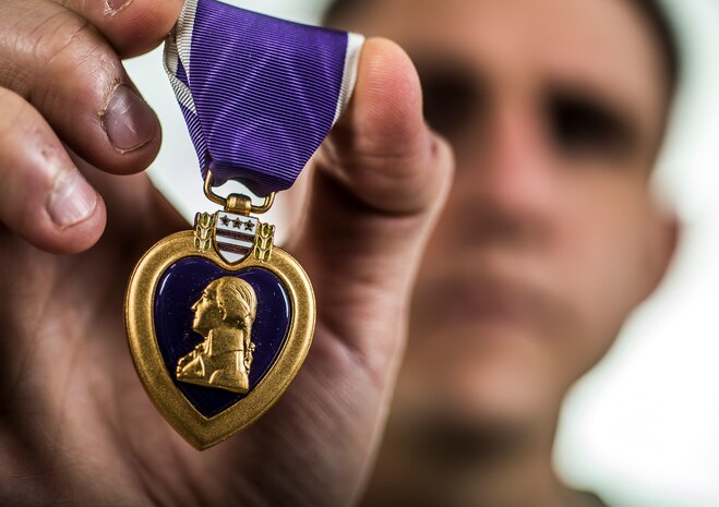 First Lt. Kevin Summerbell, 15th Airlift Squadron C-17 Globemaster III pilot, holds up the Purple Heart he received after being shot in Iraq by enemy combatants while serving in the United States Army Feb. 19, 2015, at Joint Base Charleston, S.C. Summerbell later attended Officer Training School and commissioned as an officer in the Air Force to be a C-17 pilot, the same aircraft he was flown back on after being wounded in combat. (U.S. Air Force photo/ Senior Airman Dennis Sloan)