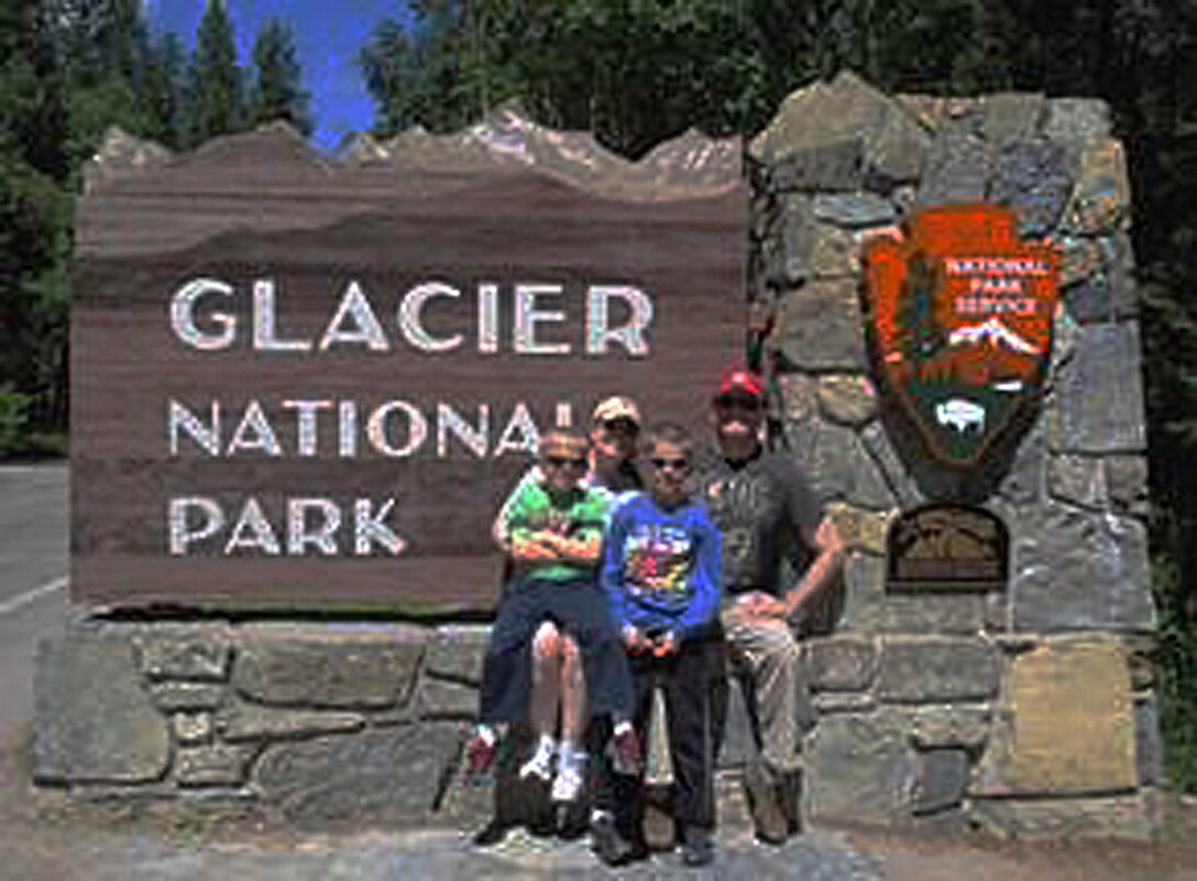 Col. Todd Sauls, 90th Operations Group commander, his wife Suzie, and his children, Jackson and Williams, pose for a photo in front of the Glacier National Park, Mont., sign. Sauls relies on his family to help him manage the stressors of being a group commander. (U.S. Air Force courtesy photo)