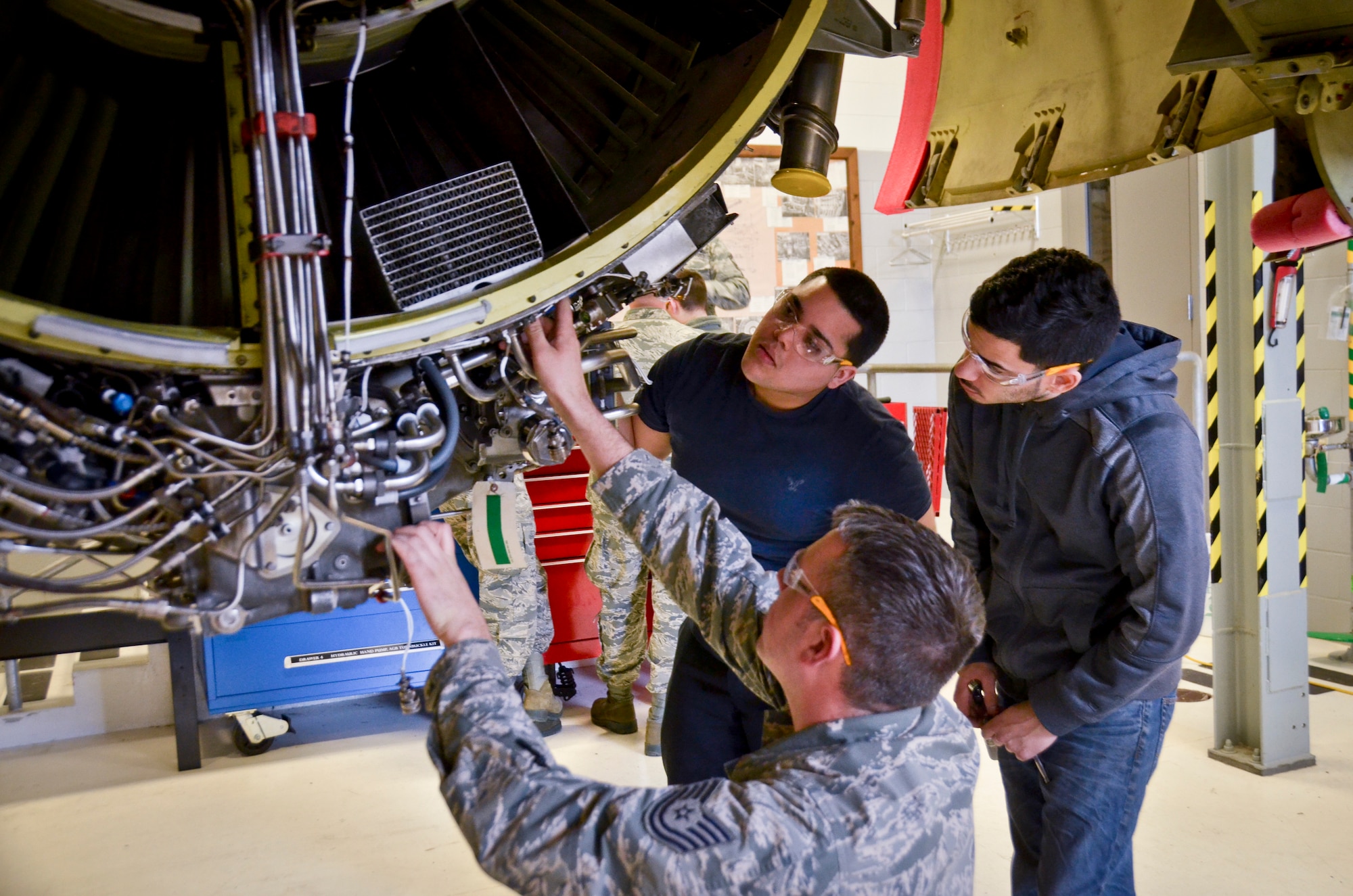 Tech. Sgt. Eric Dorn, an aerospace propulsion craftsman with the 128th Air Refueling Wing, Wisconsin Air National Guard, trains Richard Ortiz and Michael Rodriguez, students with the aviation program at the Milwaukee Area Technical College, on removal, inspection and installation of line replaceable units on an F108 turbofan engine in the propulsion shop Feb. 25 here. (U.S. Air National Guard photo by Tech. Sgt. Jenna Lenski/Released)