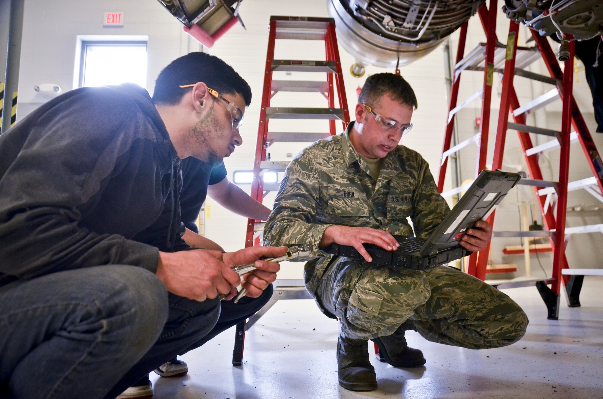Tech. Sgt. Eric Dorn, an aerospace propulsion craftsman with the 128th Air Refueling Wing, Wisconsin Air National Guard, references Air Force technical data with students with the Milwaukee Area Technical College Feb. 25.  (U.S. Air National Guard photo by Tech. Sgt. Jenna Lenski/Released)