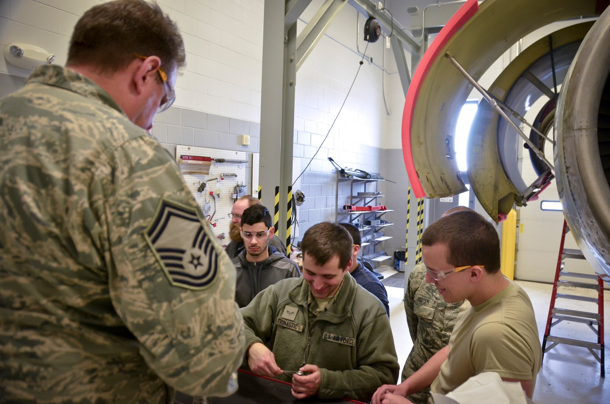 Senior Master Sgt. Michael Nuoffer, the propulsion shop supervisor with the 128th Air Refueling Wing, Wisconsin Air National Guard, instructs proper safety wire techniques on enigne mount bolts to Airmen with the propulsion shop and students with Milwaukee Area Technical College Feb. 25.  (U.S. Air National Guard photo by Tech. Sgt. Jenna Lenski/Released)