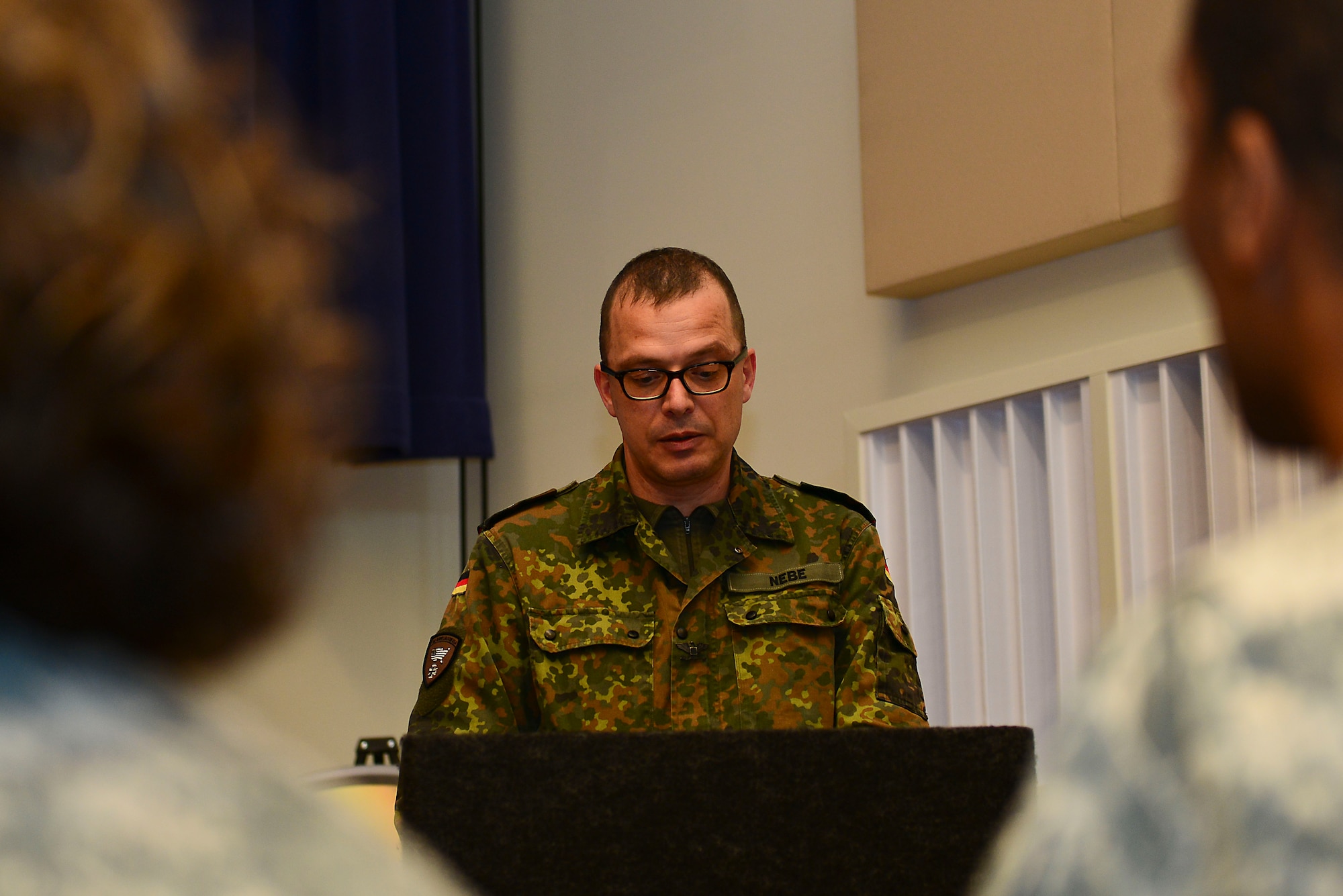 German Army Col. Johannes Nebe, Headquarters U.S. Army Training and Doctrine Command senior German Army liaison officer, speaks during the German Armed Forces Proficiency Badge award ceremony at Fort Eustis, Va., March 3, 2015. Nebe spoke about the lasting tradition of U.S. Soldiers investing efforts to earning the GAFPB. (U.S. Air Force photo by Senior Airman Kimberly Nagle/Released)