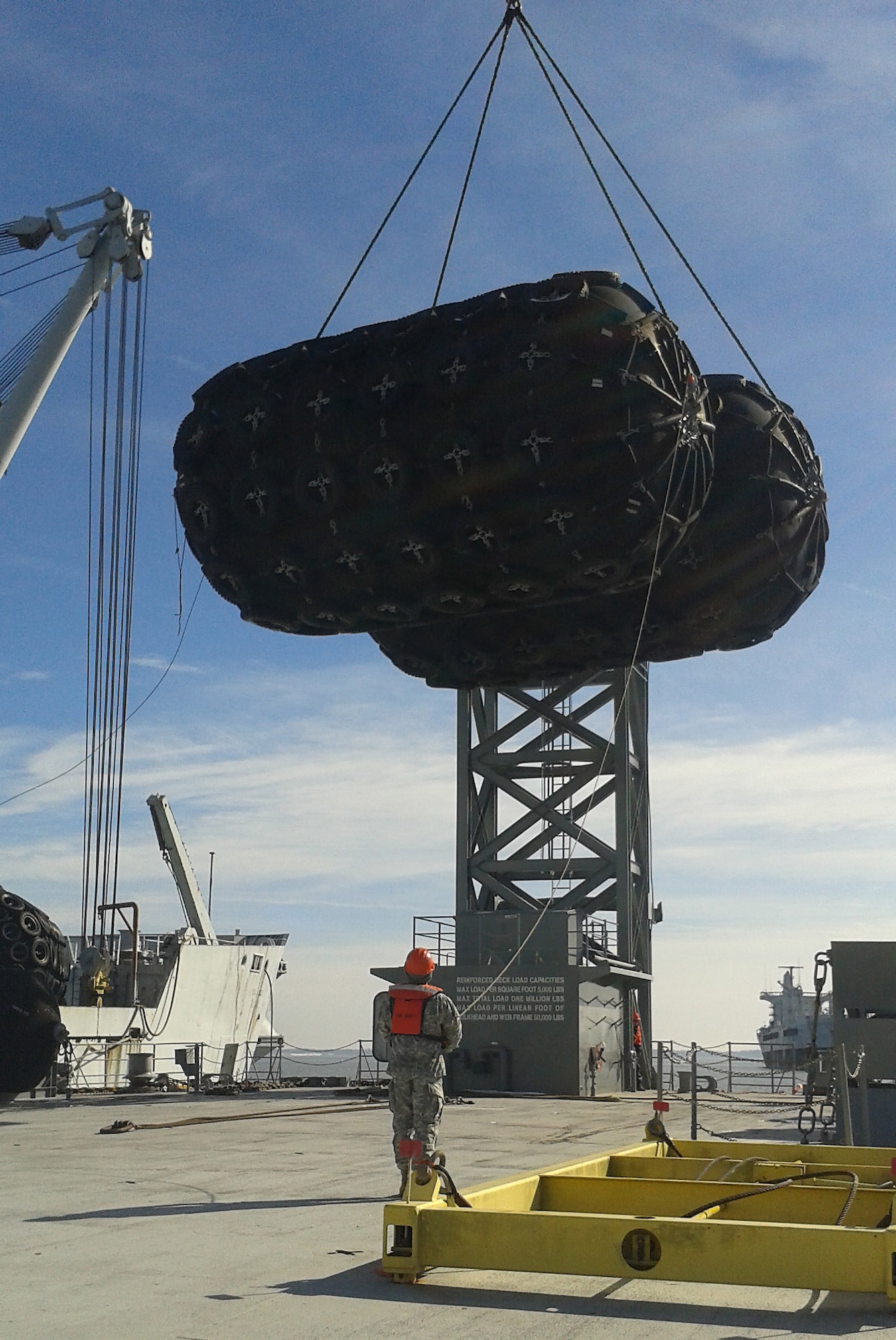 A U.S. Army Soldier from the 73rd Transportation Company, 10th Transportation Battalion, 7th Transportation Brigade (Expeditionary) observes as 16,000-pound fenders are lifted off the former Army Vessel James McHenry for the James River Reserve Fleet at Fort Eustis, Va., Feb. 25, 2015. The James McHenry is currently being decommissioned and the fenders will be repurposed for other vessels, saving the Army more than $200,000. (U.S. Army photo by Chief Warrant Officer 4 Bill Sherman/Released)