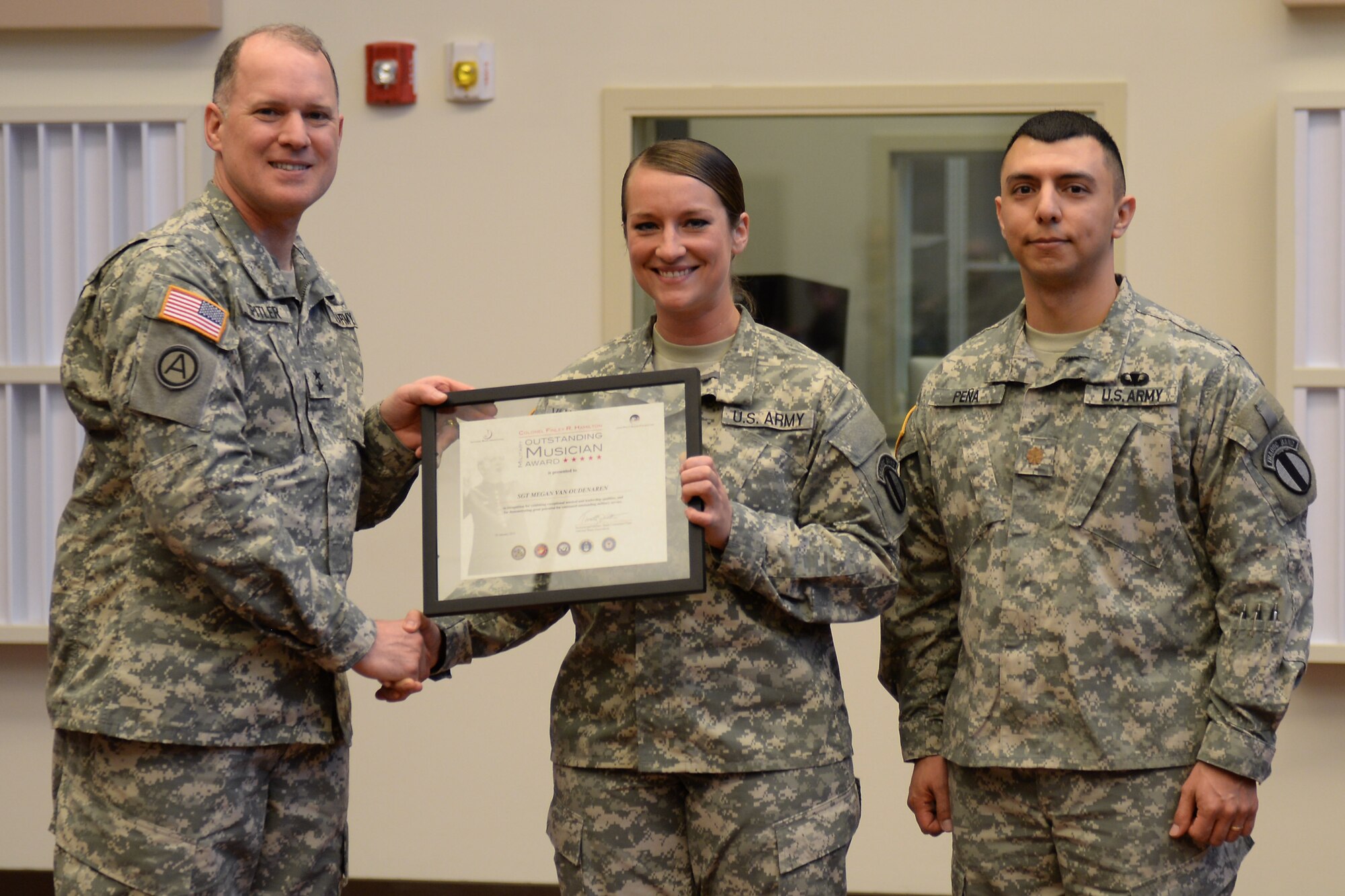 U.S. Army Maj. Gen. Rex Spitler, U.S. Army Training and Doctrine Command deputy chief of staff, and Maj. Leonel Pena, TRADOC Band commander, present the Col. Finley R. Hamilton Outstanding Military Musician Award to Sgt. Megan Van Oudenaren, TRADOC Band vocalist, at Fort Eustis, Va., March 2, 2015. To qualify for the award, nominees must be between the ranks of E-4 and E-6 and exhibit outstanding musical and leadership excellence in both solo and ensemble performances. r. (U.S. Air Force photo by Staff Sgt. Teresa J. Cleveland/Released)