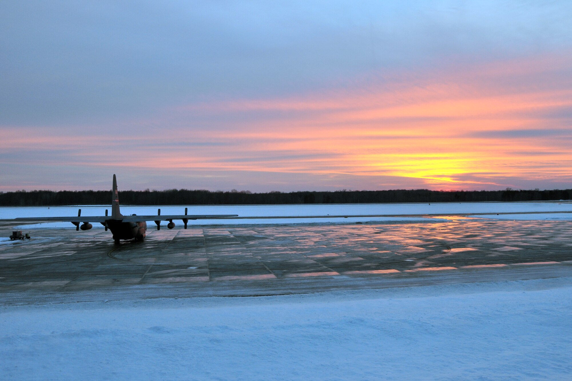 After a harsh week of winter weather, a C-130H Hercules aircraft, assigned to the 910th Airlift Wing (AW), sits on the ice-covered flight line at Youngstown Air Reserve Station, February 2015. The 910th AW’s mission is to provide tactical airlift support and is home to the Department of Defense’s only large-area, fixed wing aerial spray capability. U.S. Air Force photo/Tech. Sgt. Valerie Smock.