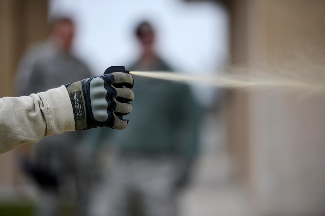 Senior Airman Daniel Miller, 47th Security Forces Squadron non-lethal weapons instructor, compresses an oleoresin capsicum canister on Laughlin Air Force Base, Texas, Feb. 27, 2015. Having completed the Marine Corps Interservice Nonlethal Individual Weapons Instructor Course at Fort Leonard Wood, Missouri, Miller is one of two certified non-lethal weapons instructors qualified to conduct OC training and certification at Laughlin. (U.S. Air Force photo by Tech. Sgt. Steven R. Doty)(Released)