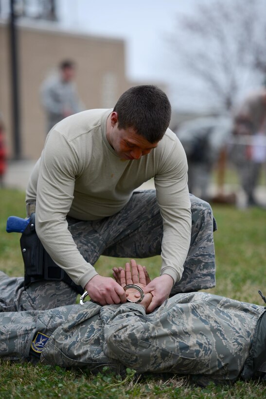 Senior Airman Jonathan Shoumaker, 47th Security Forces Squadron patrolman, handcuffs a mock attacker after a level one contamination of oleoresin capsicum on Laughlin Air Force Base, Texas, Feb. 27, 2015. Level one OC contamination certification includes fight-through drills, handcuff positions, verbal commands, mechanical advantage control holds and several additional techniques used during suspect apprehension that help build confidence in their abilities to perform and apprehend subjects after indirect and direct, accidental or residual exposure. (U.S. Air Force photo by Tech. Sgt. Steven R. Doty)(Released)