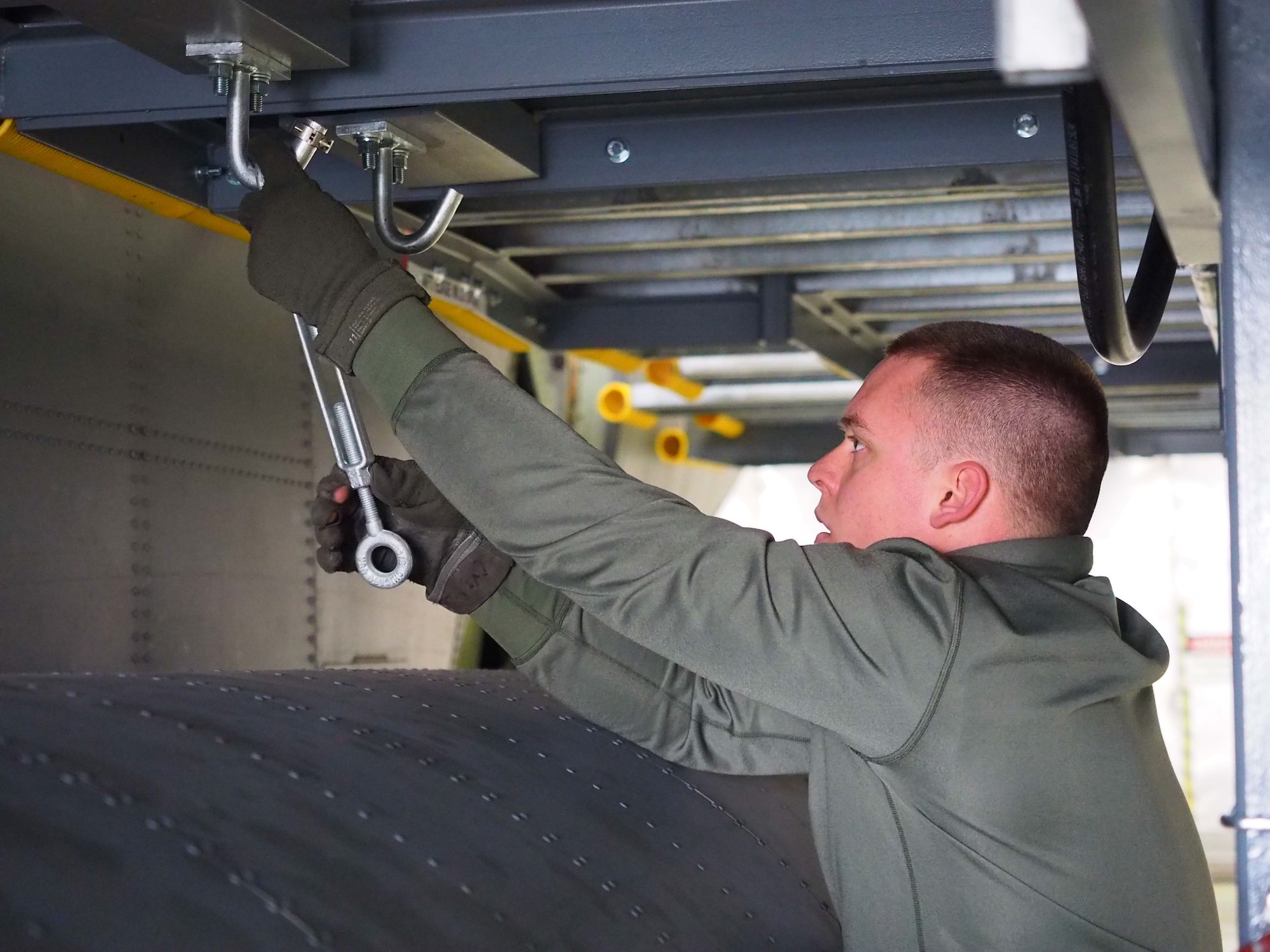 Senior Airman Jacob Haefemeyer, 934th Maintenance Squadron, attaches a turnbuckle to hold sections of the ISO stand together. (Air Force Photo/Paul Zadach)
