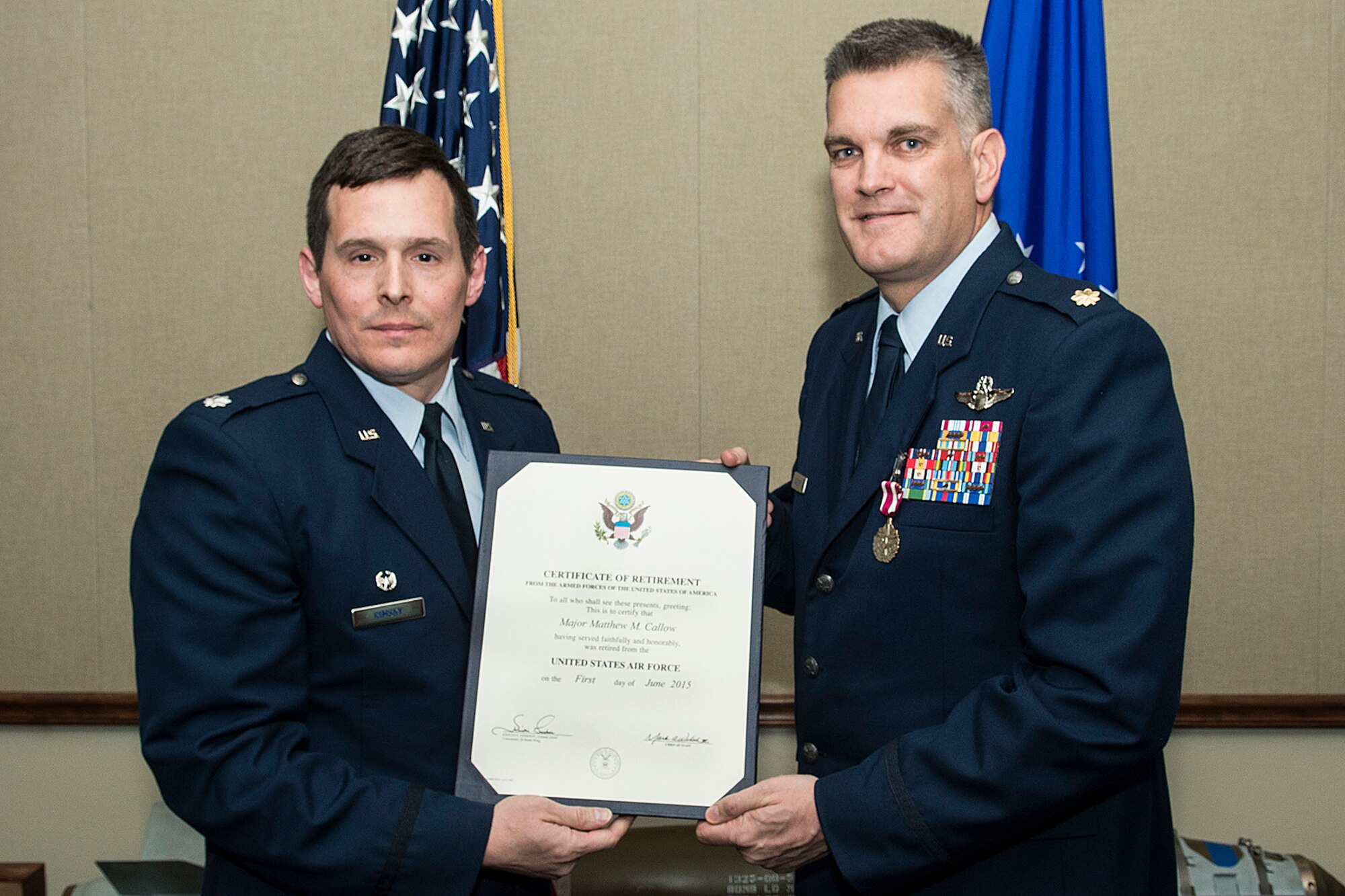 U.S. Air Force Maj. Matthew Callow (right), is presented his retirement certificate during a ceremony on Feb. 27, 2015, Barksdale Air Force Base, La. Callow is a B-52H Stratofortress pilot assigned to the 11th Bomb Squadron and is retiring after 20 years of service. (U.S. Air Force photo by Master Sgt. Greg Steele/Released)