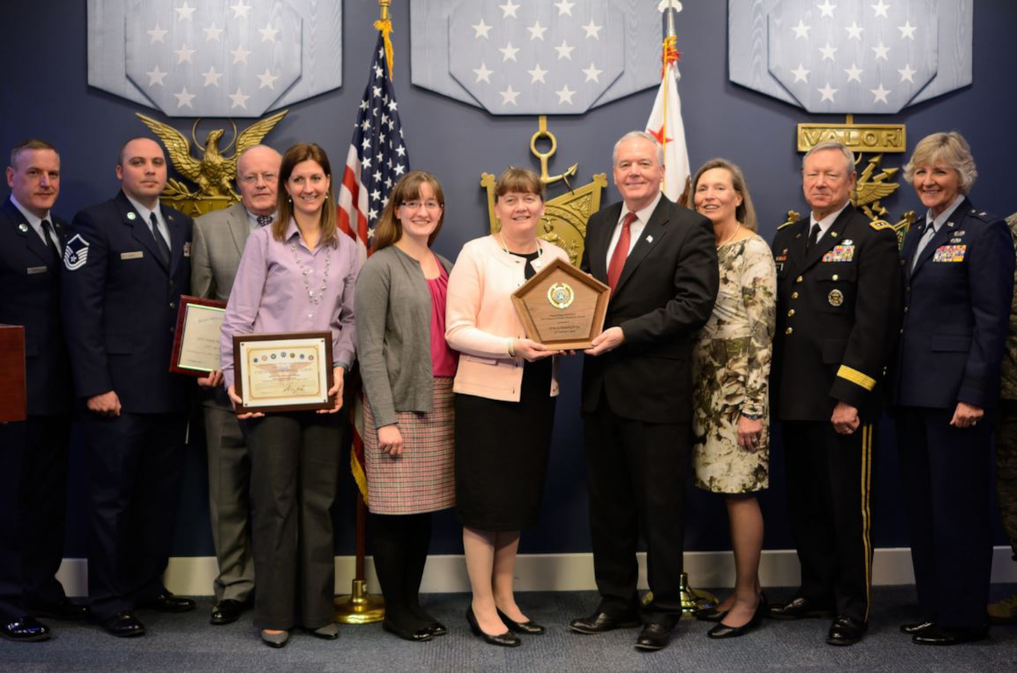 Bonnie Rice (center) accepts on behalf of the 157th Air Refueling Wing Airman and Family Readiness Program a plaque for the 2014 Reserve Family Readiness Awards from Richard O. Wightman Jr., principal deputy assistant secretary of defense for reserve affairs, during a ceremony at the Pentagon's Hall of Heroes, Feb. 27. DOD honored the top unit in each reserve component for its outstanding programs that support unit missions and family readiness. (DoD photo by Steve Turner, Office of the Secretary of Defense, Reserve Affairs)