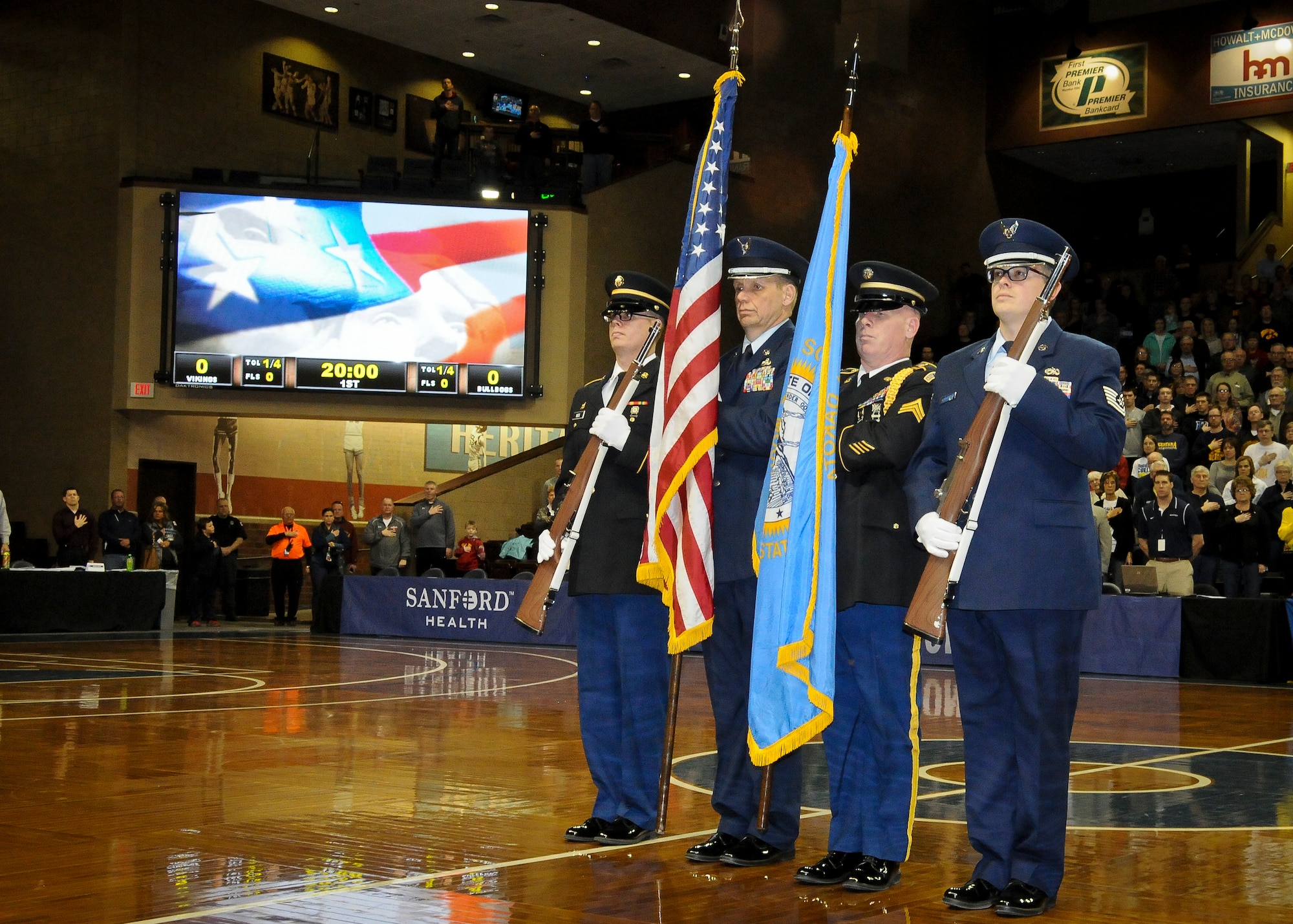 SIOUX FALLS, S.D. - Members of the South Dakota Air and Army National Guard posts the colors during the national anthem at the Northern Sun Intercollegiate Conference NCAA II basketball tournament in Sioux Falls, S.D., March 1, 2015.  (National Guard photo by Staff Sgt. Luke Olson/Released)