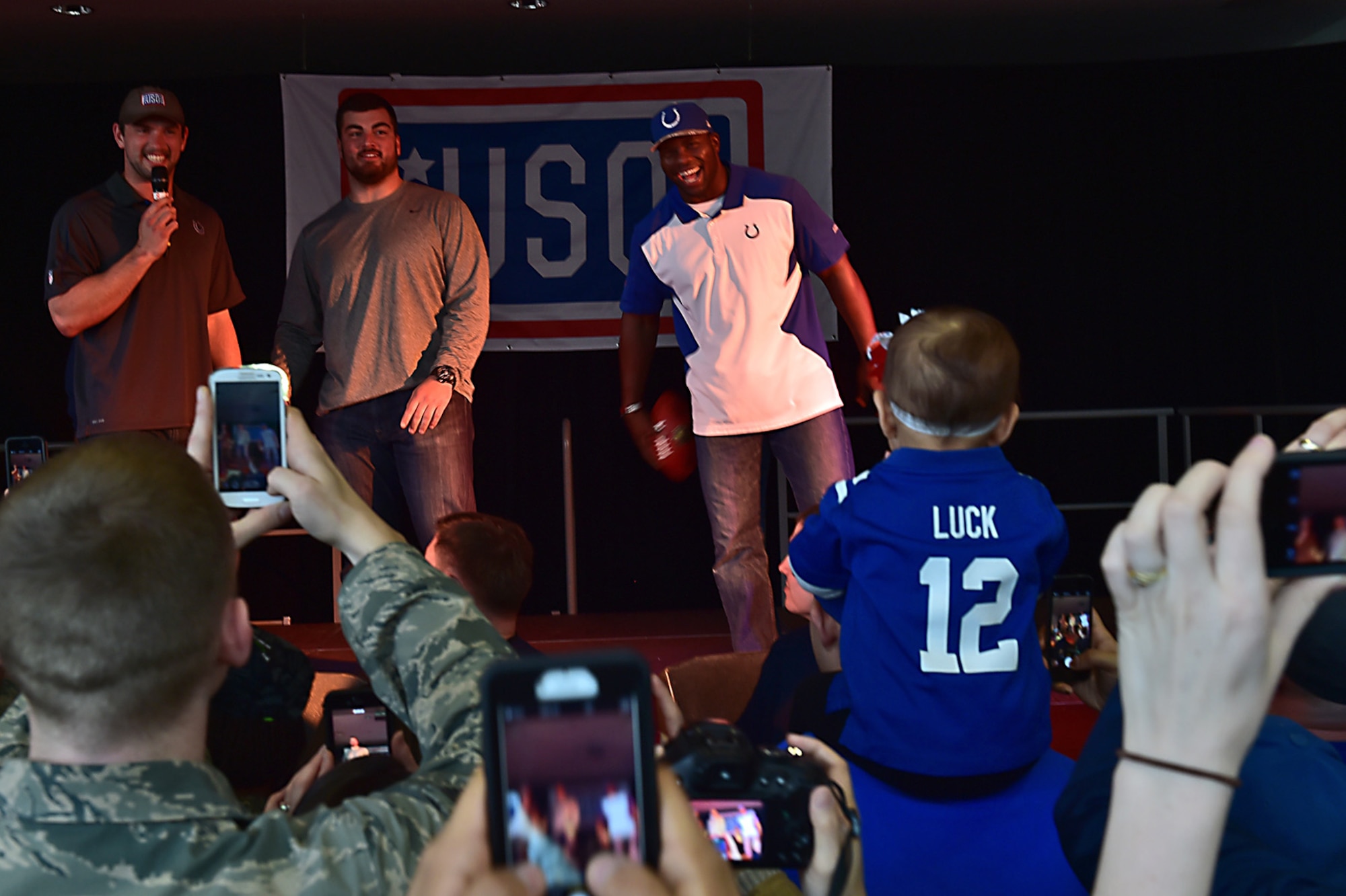 Military members take photos of Andrew Luck, left, Indianapolis Colts quarterback, David DeCastro, center, Pittsburgh Steelers guard, and Dwayne Allen, Indianapolis Colts tight end, during the USO Spring Visit at Ramstein Air Base, Germany, March 3, 2015. For their first stop of a multi-country tour, the USO brought Indianapolis Colts players Andrew Luck and Dwayne Allen, Colts coach Chuck Pagano, Pittsburgh Steelers player David DeCastro, entertainers Philip Phillips, Dennis Haysbert, Miss America 2015, Ace Young, Diana DeGarmo, and Jason “Wee Man” Acuna to Ramstein to visit military members and their families. (U.S. Air Force photo/Staff Sgt. Sara Keller) 