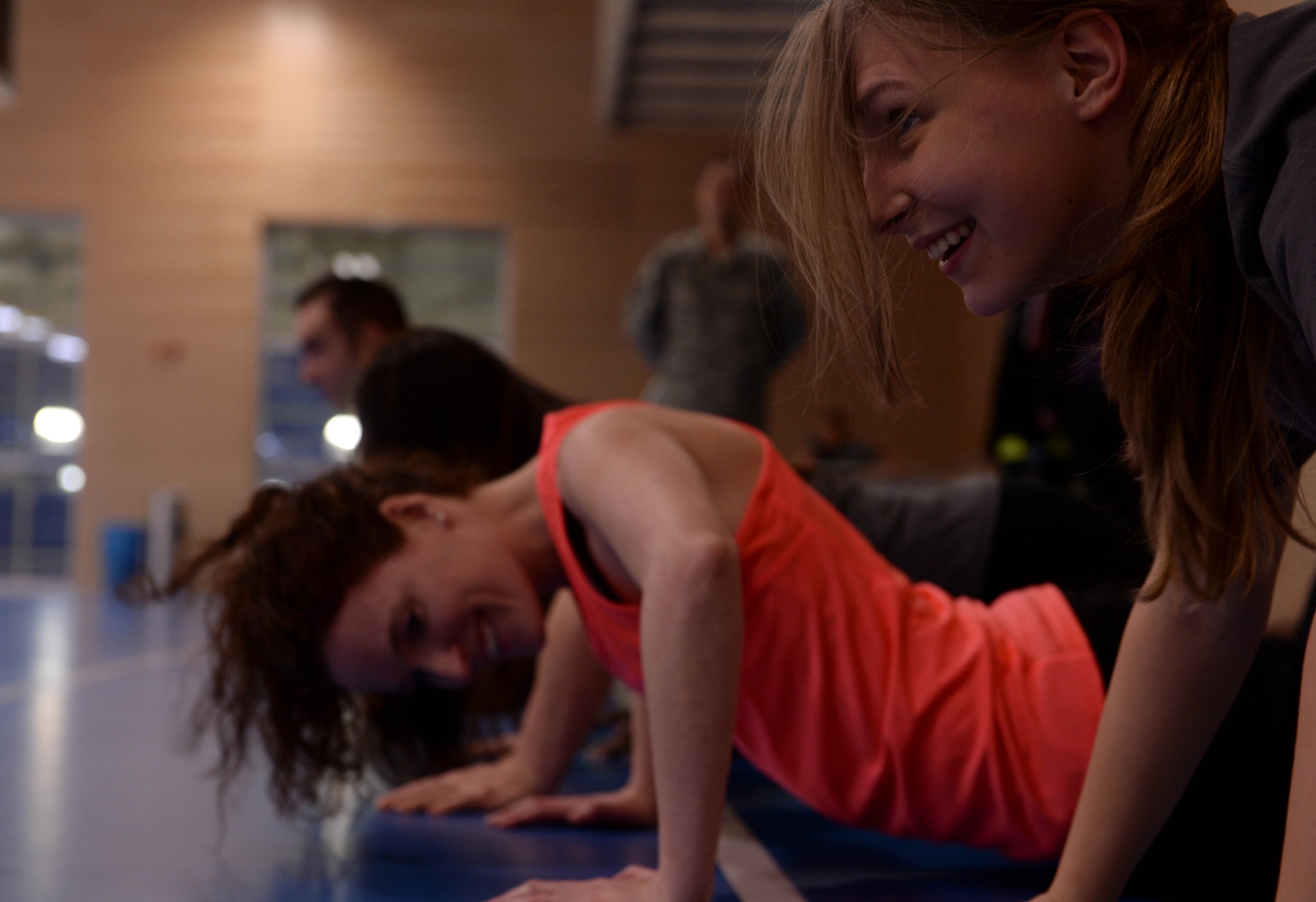 U.S. Air Force Airman Kimberly Collins, right, 52nd Force Support Squadron fitness apprentice, performs push-ups with her teammates during the relay race of the Turbo-Charged Challenge #2 at the Eifel Powerhaus at Spangdahlem Air Base, Germany, Jan. 27, 2015. A representative of each team ran to the other side of the track and back while their teammates performed calisthenics until the runners returned. The 52nd Aerospace Medicine Squadron and Eifel Powerhaus’ program intended the challenge to aid participants to live a healthier lifestyle. (U.S. Air Force photo by Airman 1st Class Timothy Kim/Released)