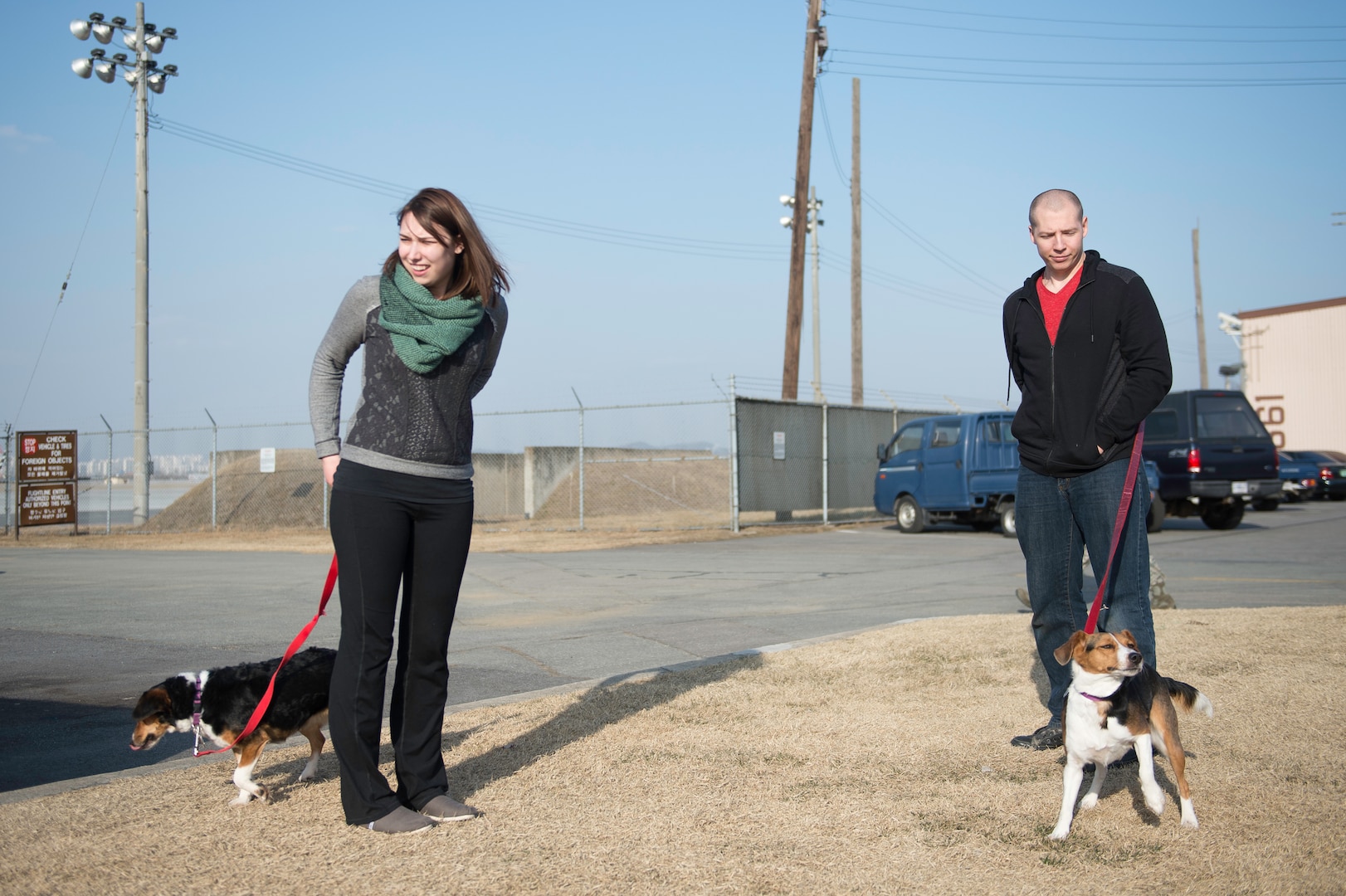 Army Sgt. Stephen Adams and his wife Elena walk their dogs for the first time after in processing the Osan Air Base passenger terminal, Republic of Korea, March 2, 2015. Sergeant Adams arrived on the Peninsula that day to join the 2nd Battalion, 2nd Aviation Regiment, 2nd Infantry Division at Camp Humphreys, Republic of Korea, as a UH-60 Black Hawk helicopter crew chief. (U.S. Air Force photo by Staff Sgt. Shawn Nickel/Released)