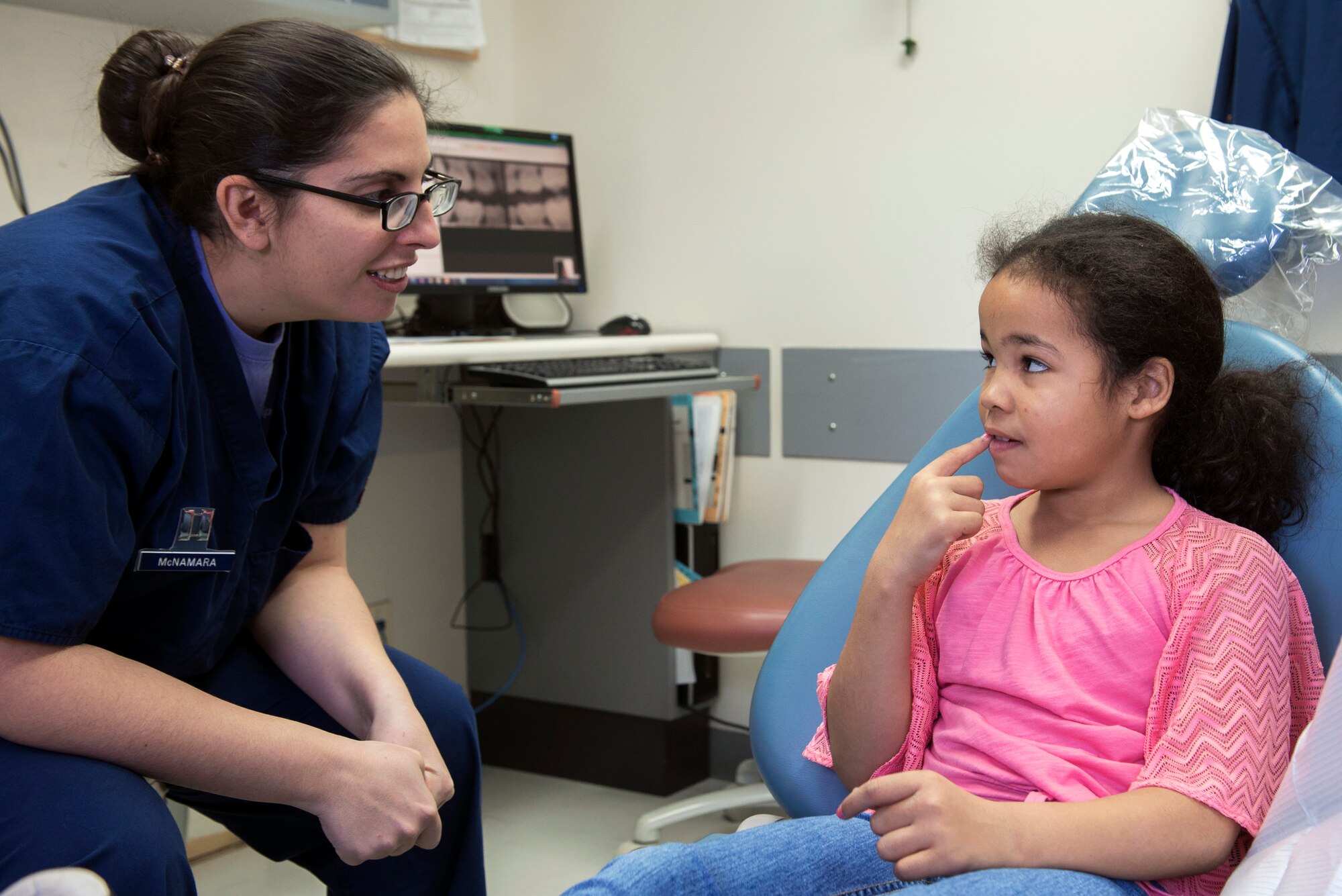 Capt. Erin McNamara, 374th Dental Squadron general dentist, speaks with Paige Lukes, a patient at the Yokota Dental Clinic, Feb. 28, 2015, during the Little Teeth-Big Smiles event. McNamara informed Lukes that her teeth are in great condition. (U.S. Air Force photo by Airman 1st Class Delano Scott/Released) 