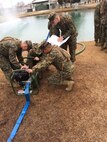 Marines working on a pump and water purifier.